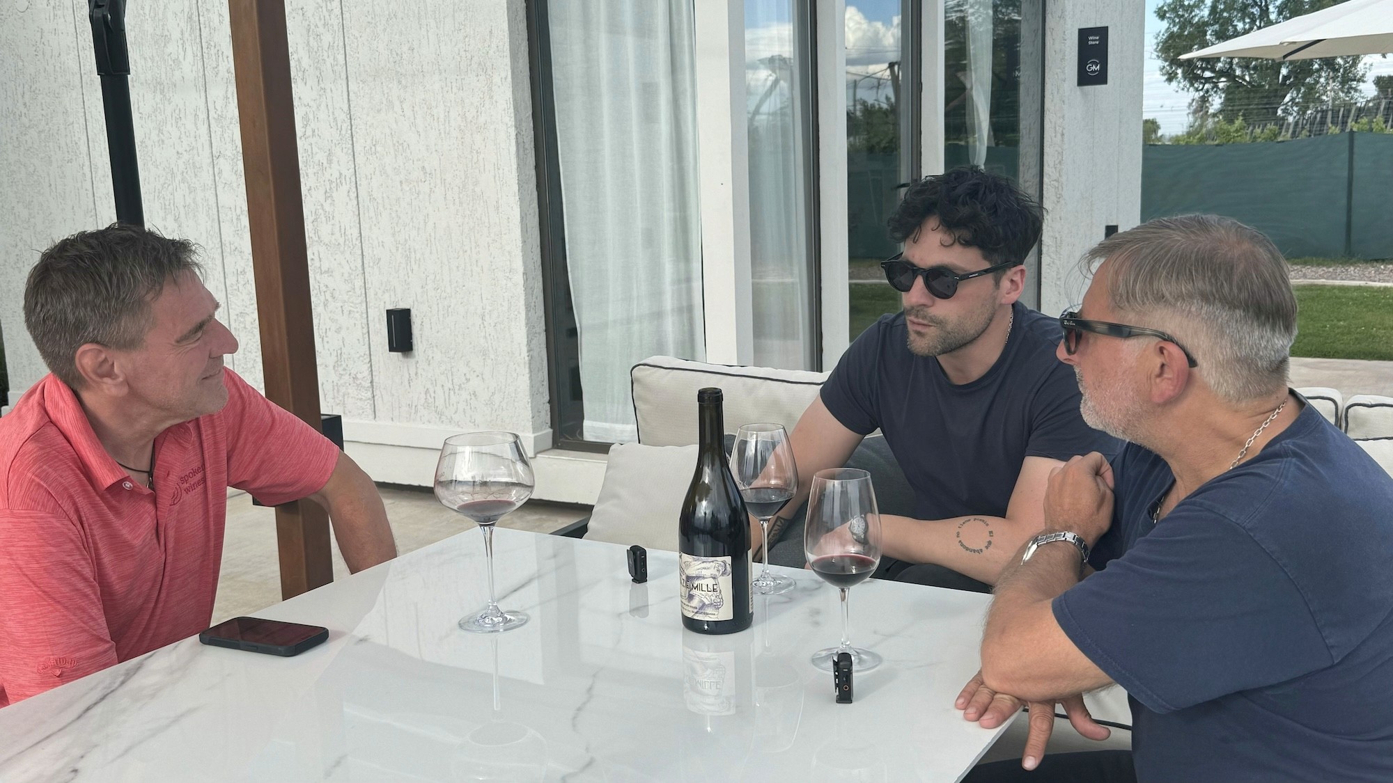 Jan de Weerd speaking with Grazie Mille founders Fernando Spigatin and Leandro over glasses of wine