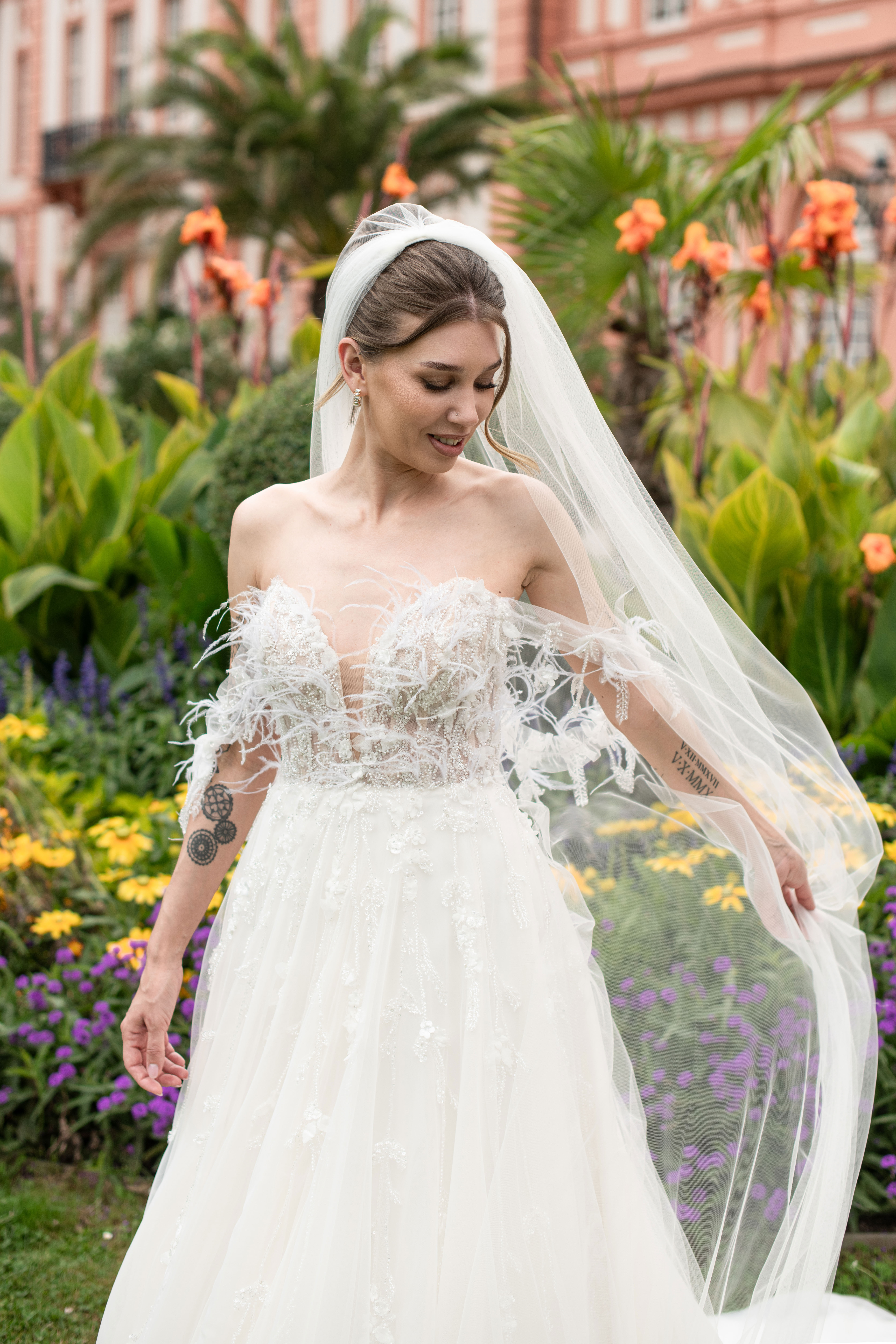 Eine Braut in einem verspielten Hochzeitskleid berät sich mit ihrer Stylistin.