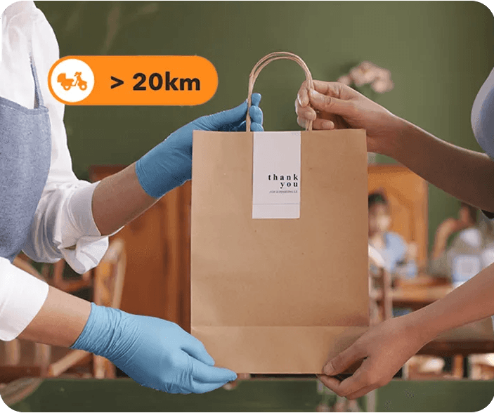 Philippine F&B staff handing over a takeaway order prepared through StoreHub online ordering with extended delivery coverage.