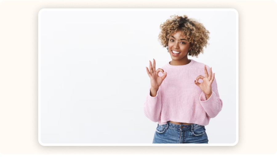 Femme souriante faisant geste OK avec mains sur fond clair.