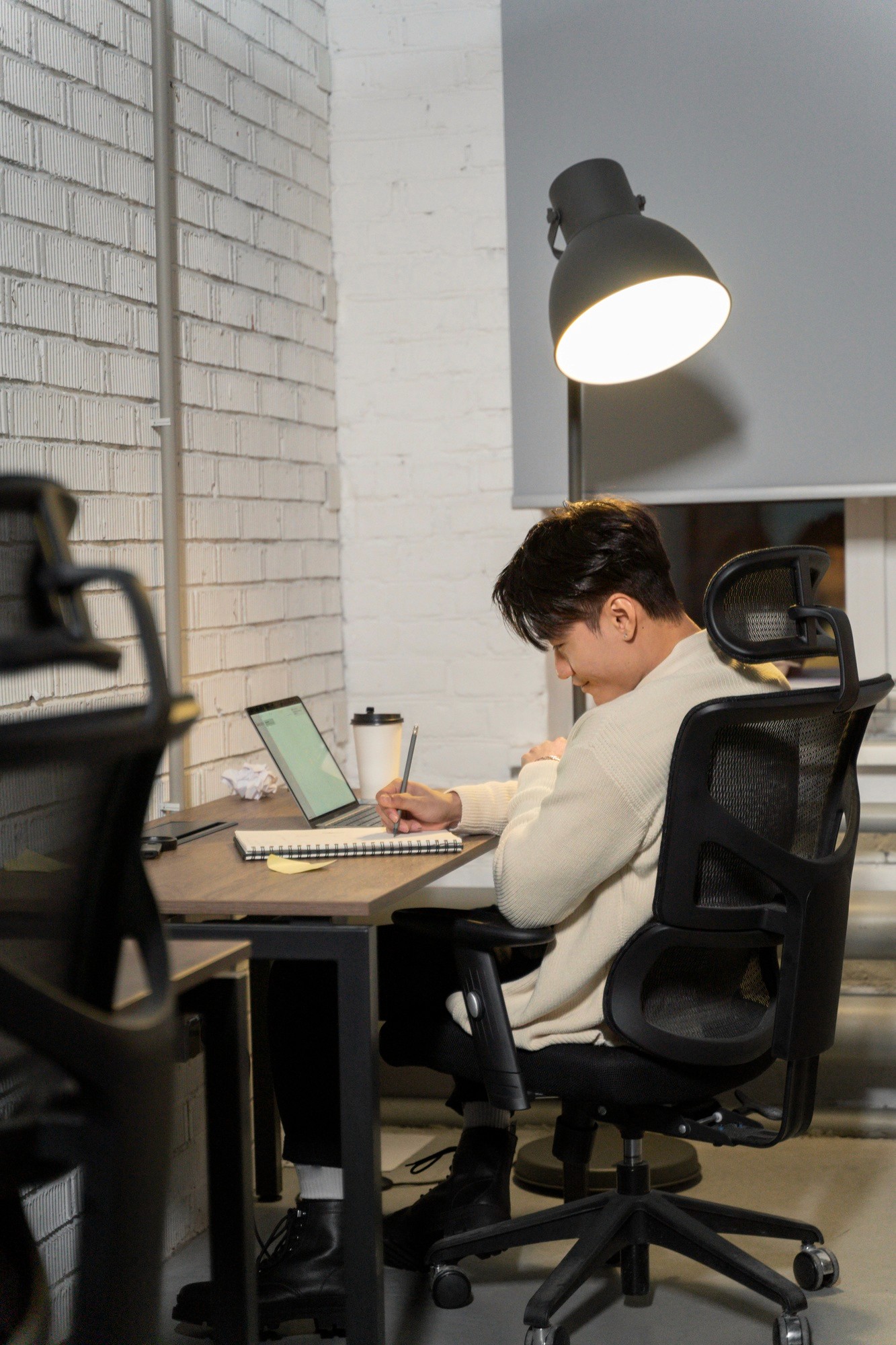 Modern living room with abstract art, beige sectional sofa, indoor plants, and large windows.