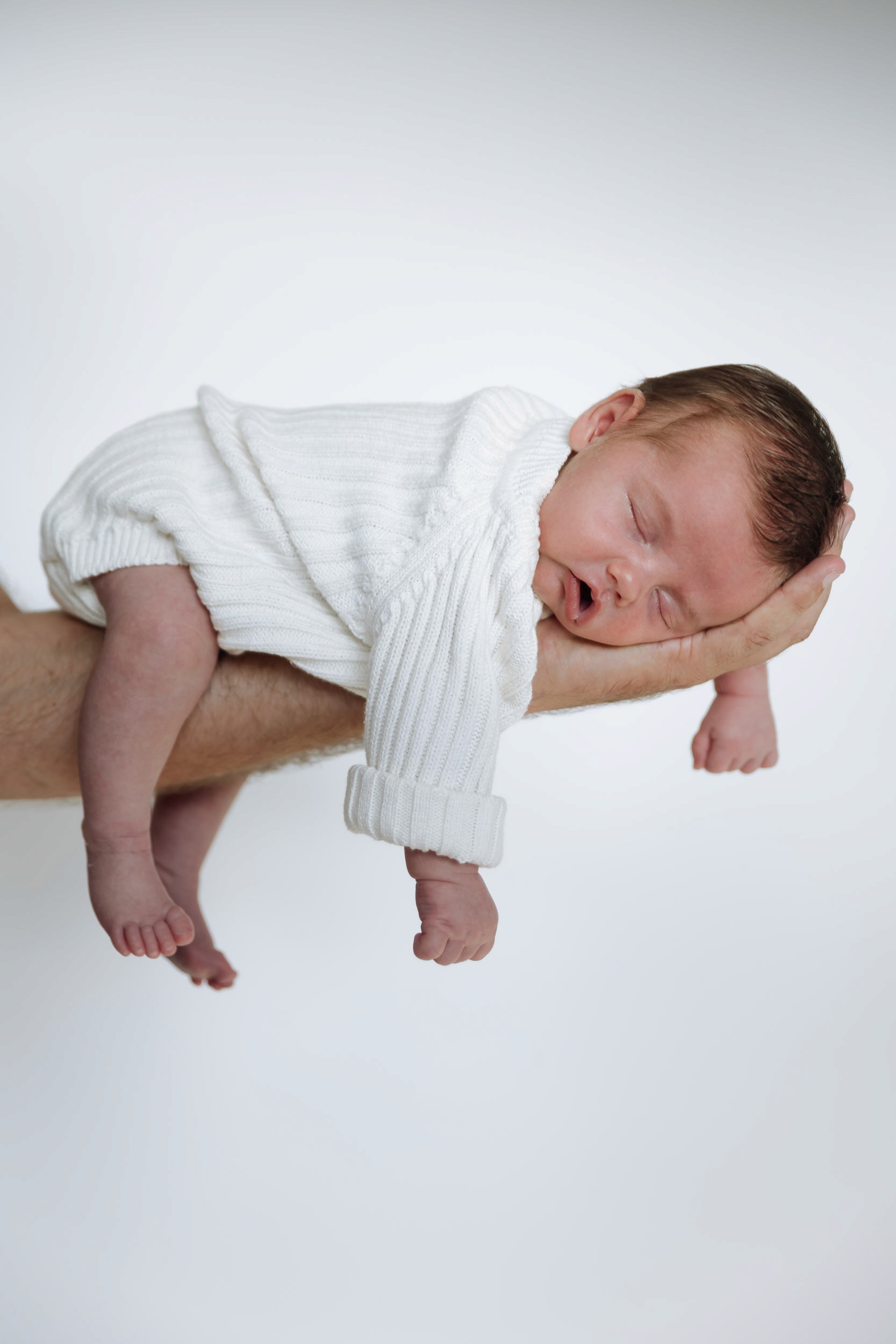 Newborn baby laying on parents arm during newborn photos in mackay