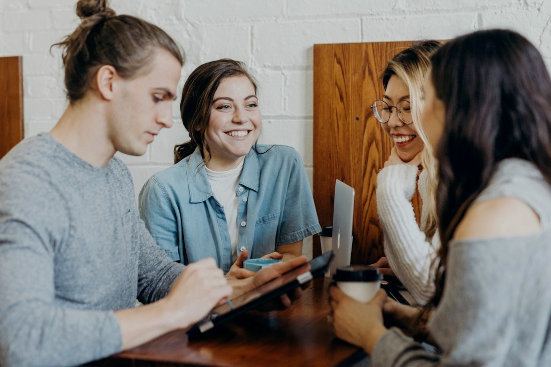 A small team working together and smiling around a table