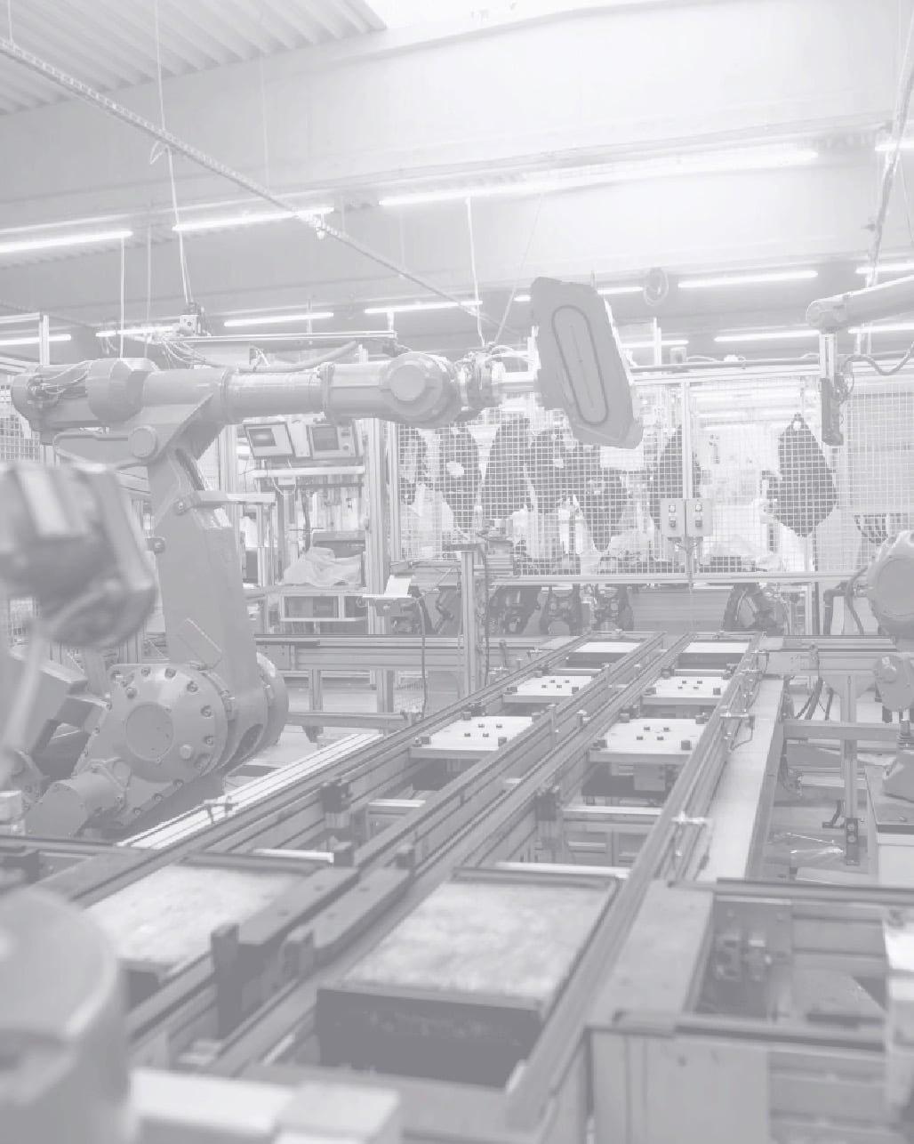 In einer modernen Produktionshalle bewegen Roboterarme Bauteile auf einer automatisierten Linie.