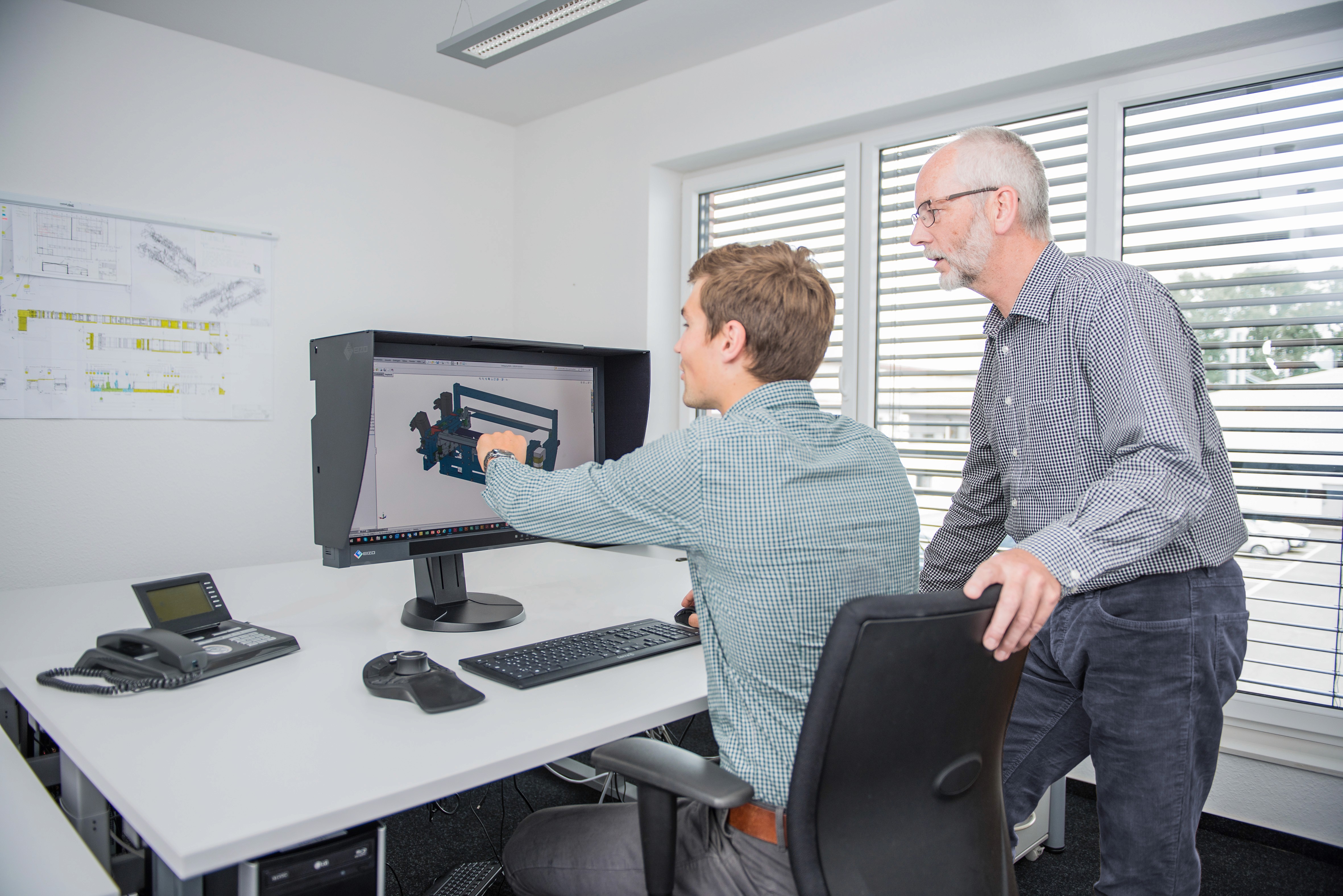 Engineers discussing a 3D model on a computer. Design & development in the office.