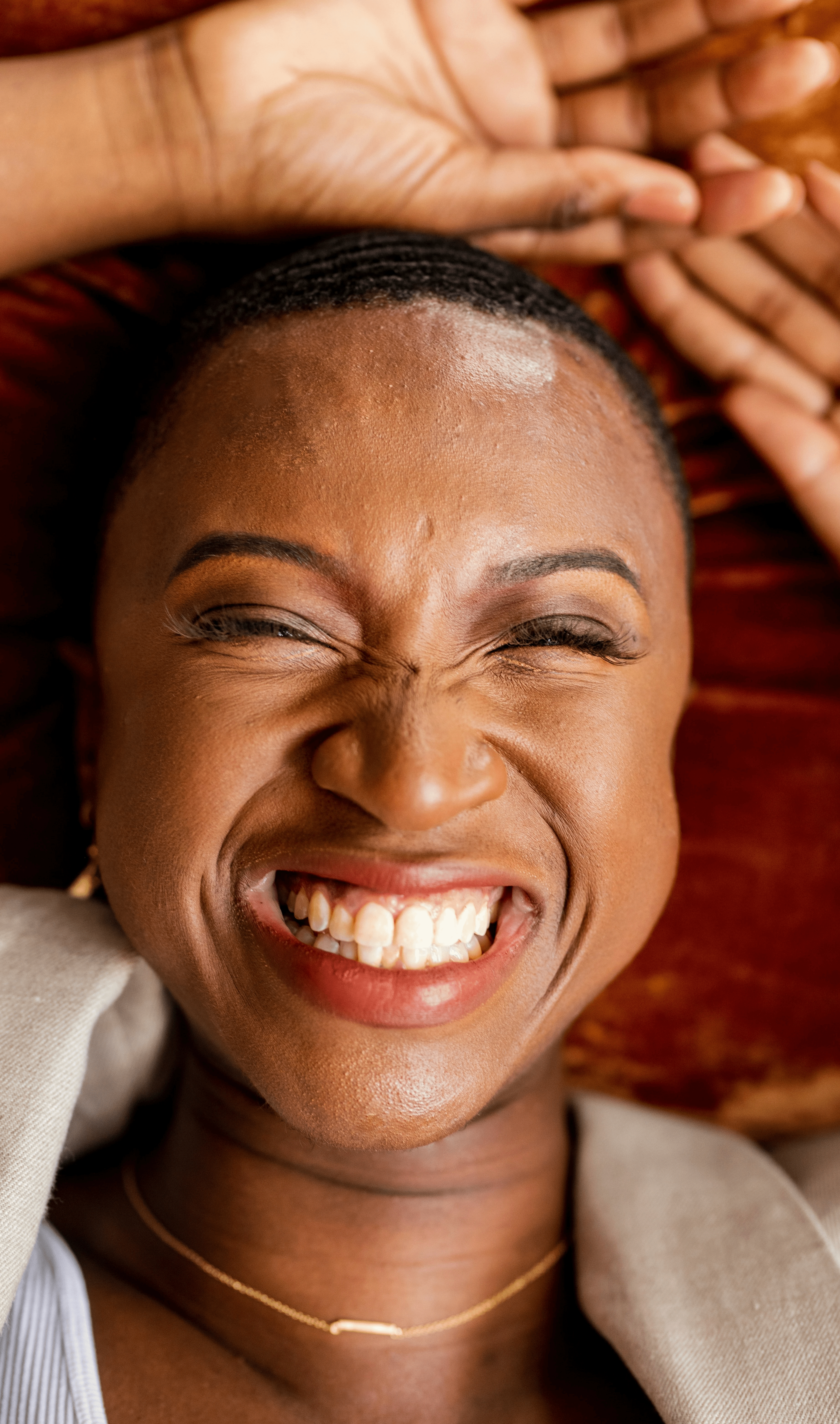 A woman smiling with her hands on her head