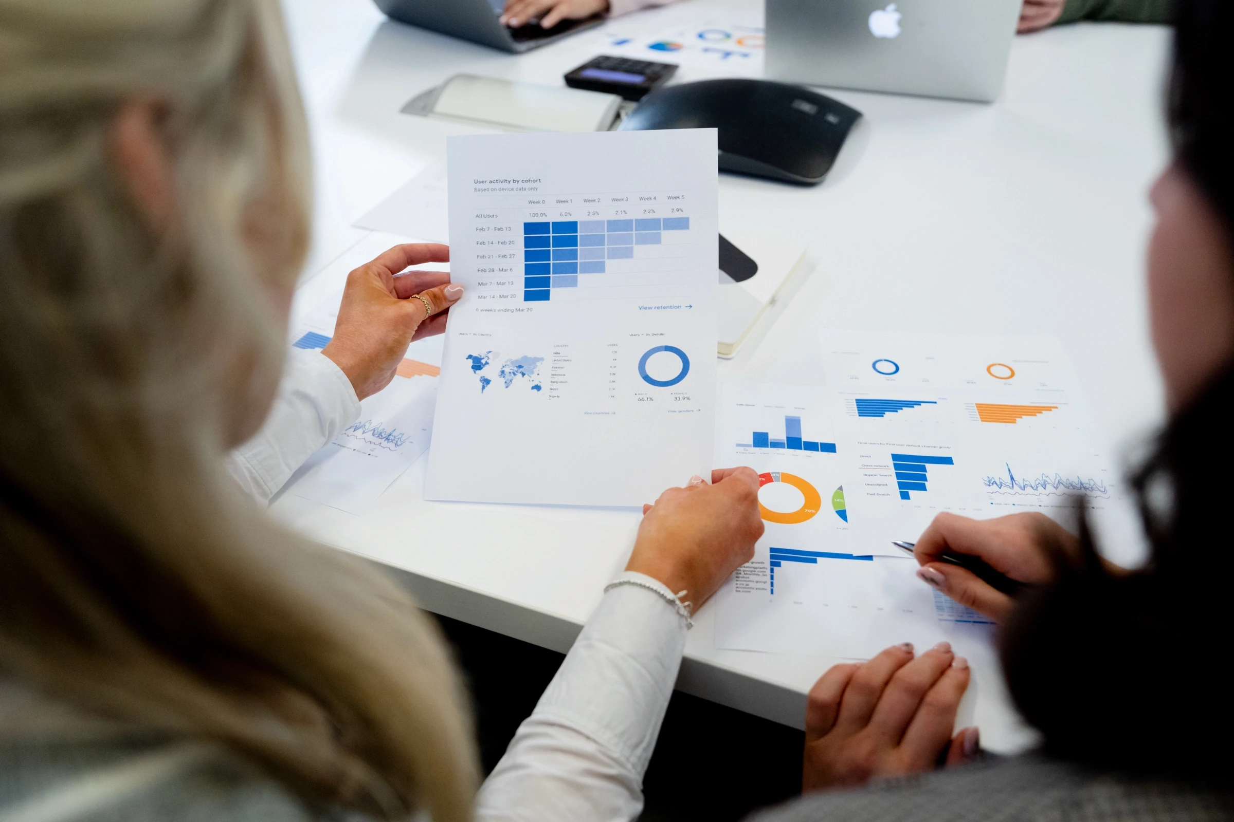 A group of people reviewing charts and graphs during a data analysis meeting.