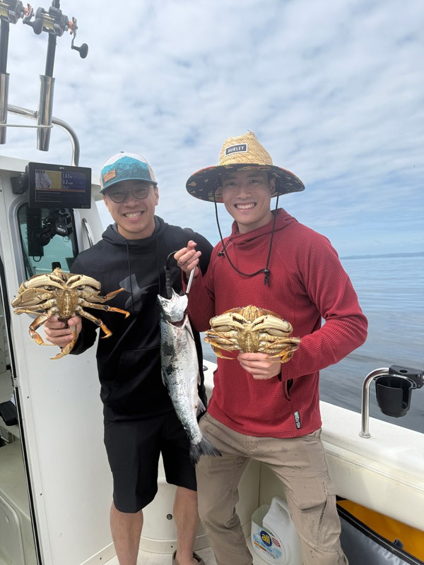 Guys holding dungeness crab and salmon