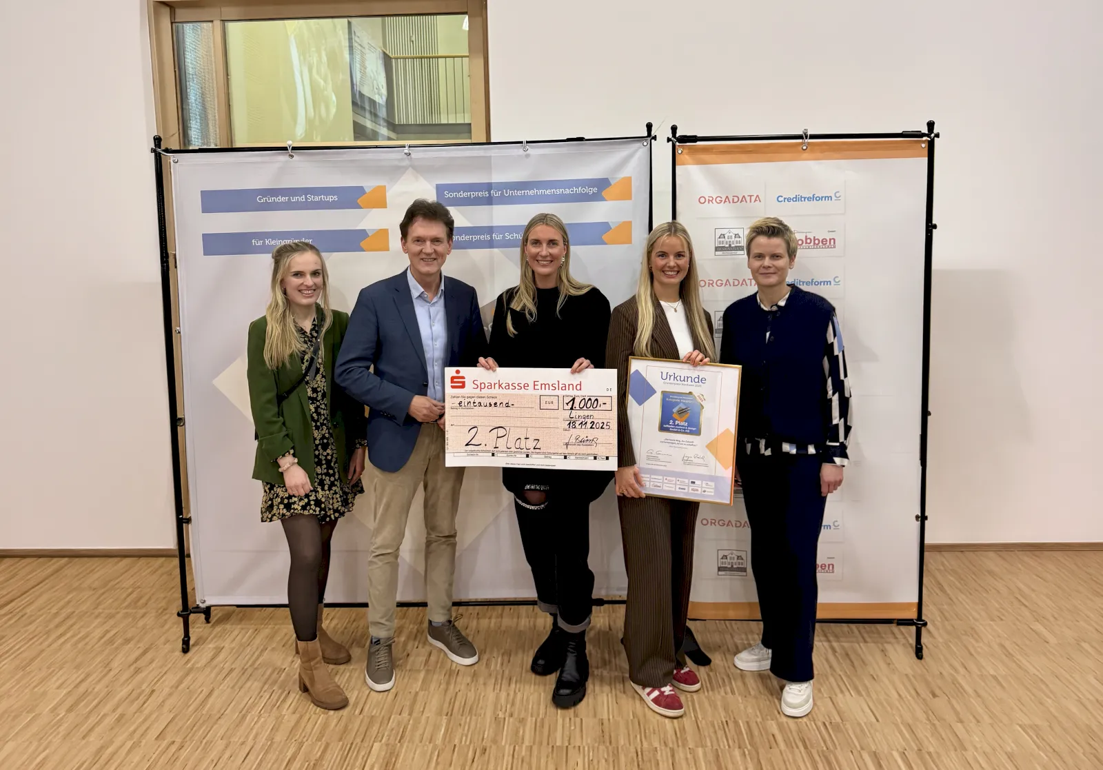 Gruppe von Personen präsentiert Scheck. Spendenübergabe der Sparkasse. 