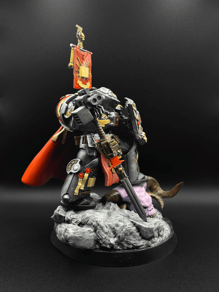 Ručně malovaná figurka Space Marine kapitána ze světa Warhammer 40K v černé zbroji s červeným pláštěm a bannerem