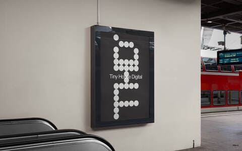 A billboard in a train station with a design for Tiny House Digital..