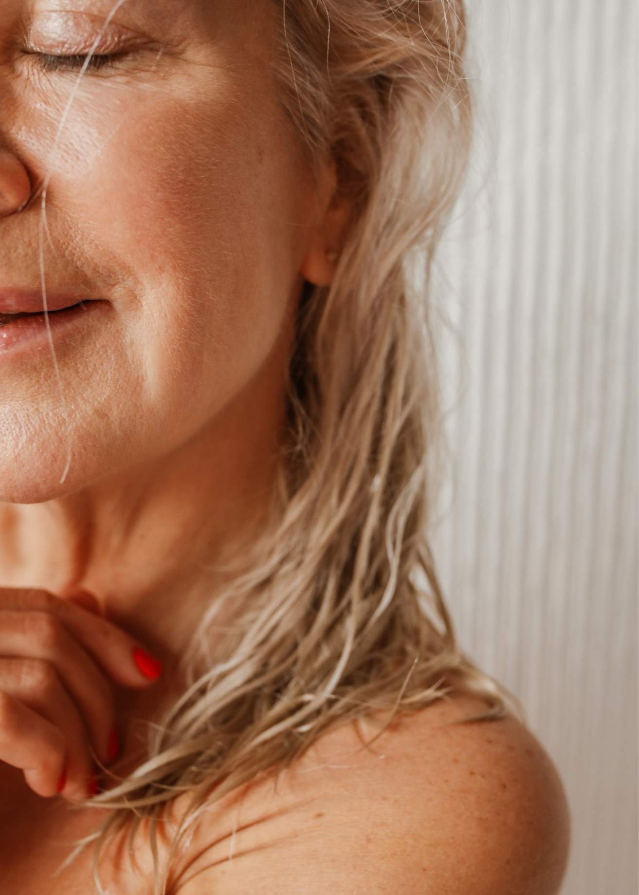 Close-up portrait of a mature woman with wet hair used for UMA women’s wellness branding, representing natural aging, health, and empowerment.