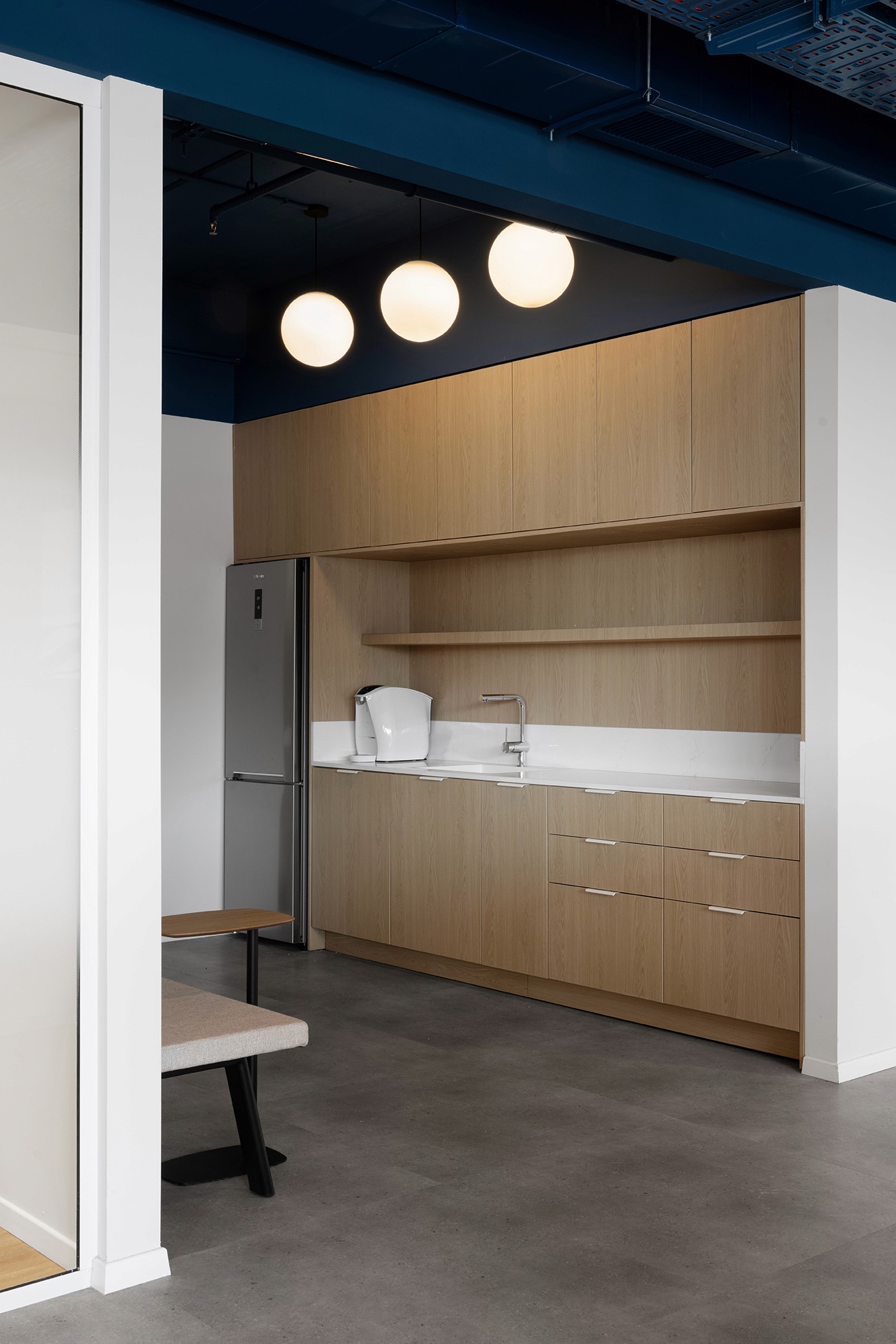 מטבחון מחלקתי (Coffee Point): יחידת נגרות עצמאית בחיפוי עץ אלון המשתלבת בנישה בנויה – פתרון אסתטי ופונקציונלי