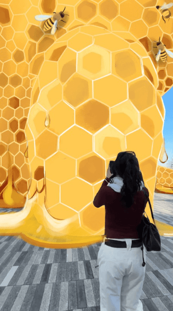 A storyboard view of a woman standing in front of the massive sculpture, preparing to interact with it