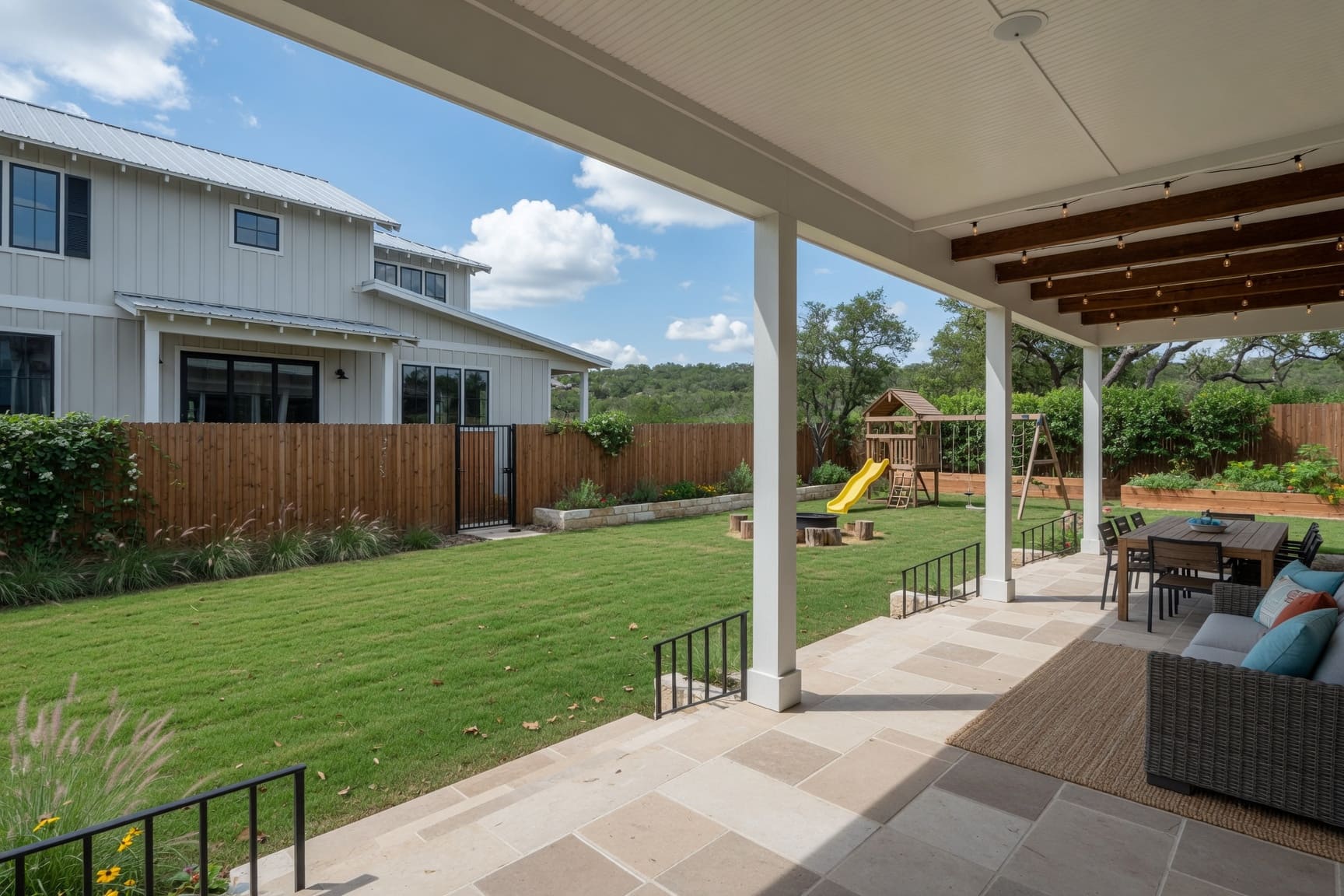 Covered back patio overlooking large backyard with play area