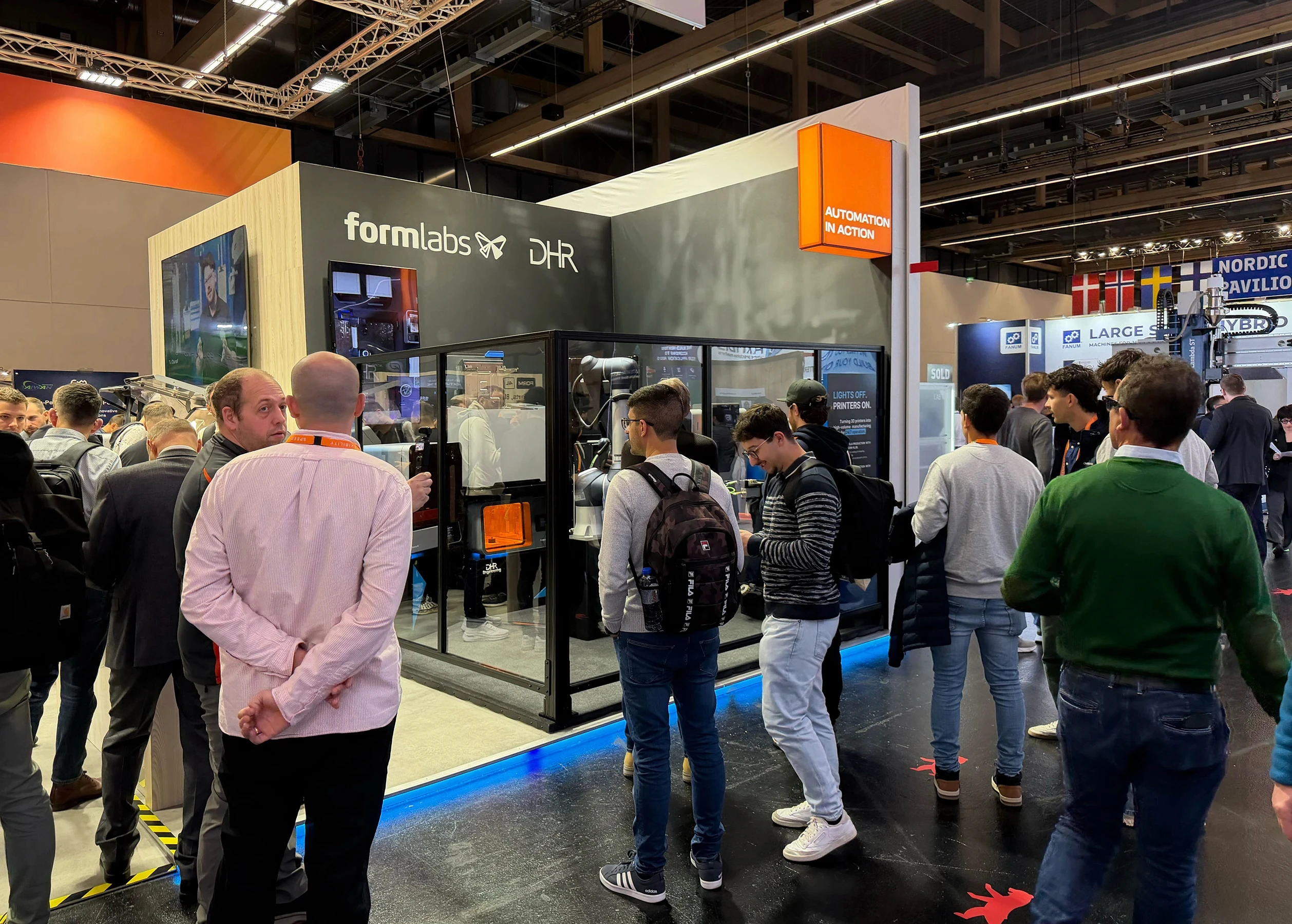 DHR Engineering's automation cell at Formnext 2025 at the Formlabs booth with lots of people around looking at it