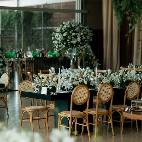 Elegant wedding reception tables with floral centerpieces and gold chairs set inside Sudeley Castle