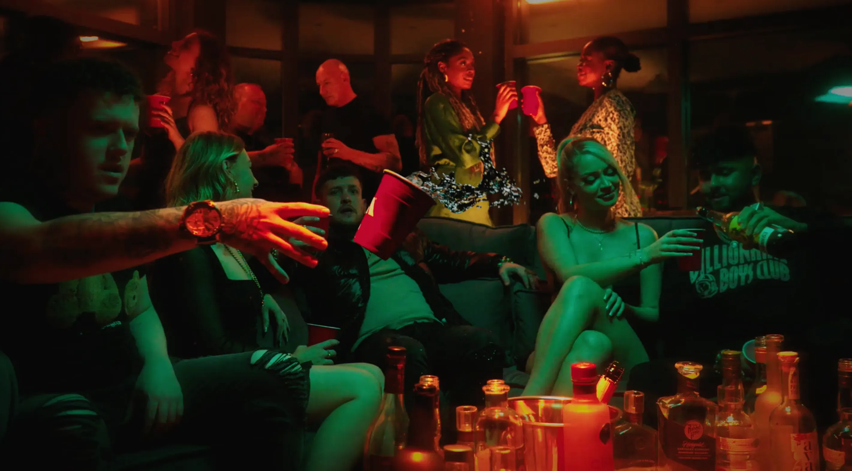 A man sat down in a bar in London surrounded by women and drinks