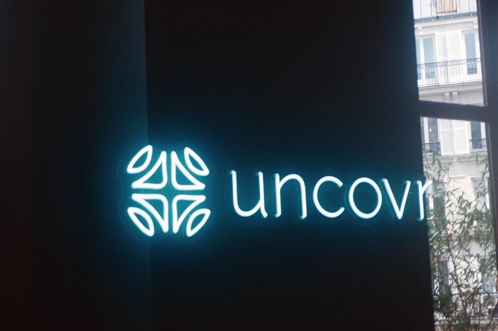 neon blue sign that says uncovr with their company logo