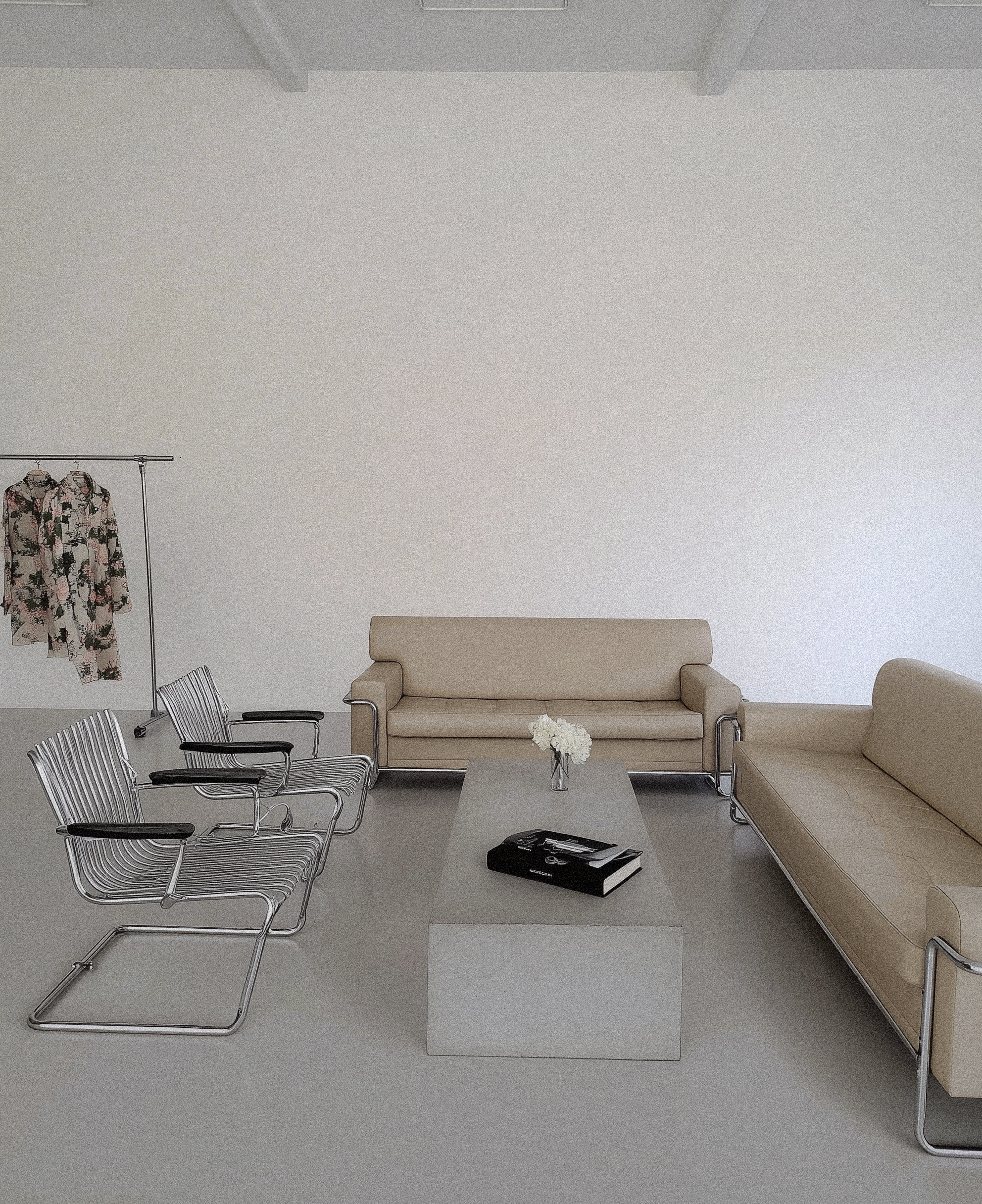 Minimal lounge interior with chrome chairs, beige sofas, and a concrete coffee table.