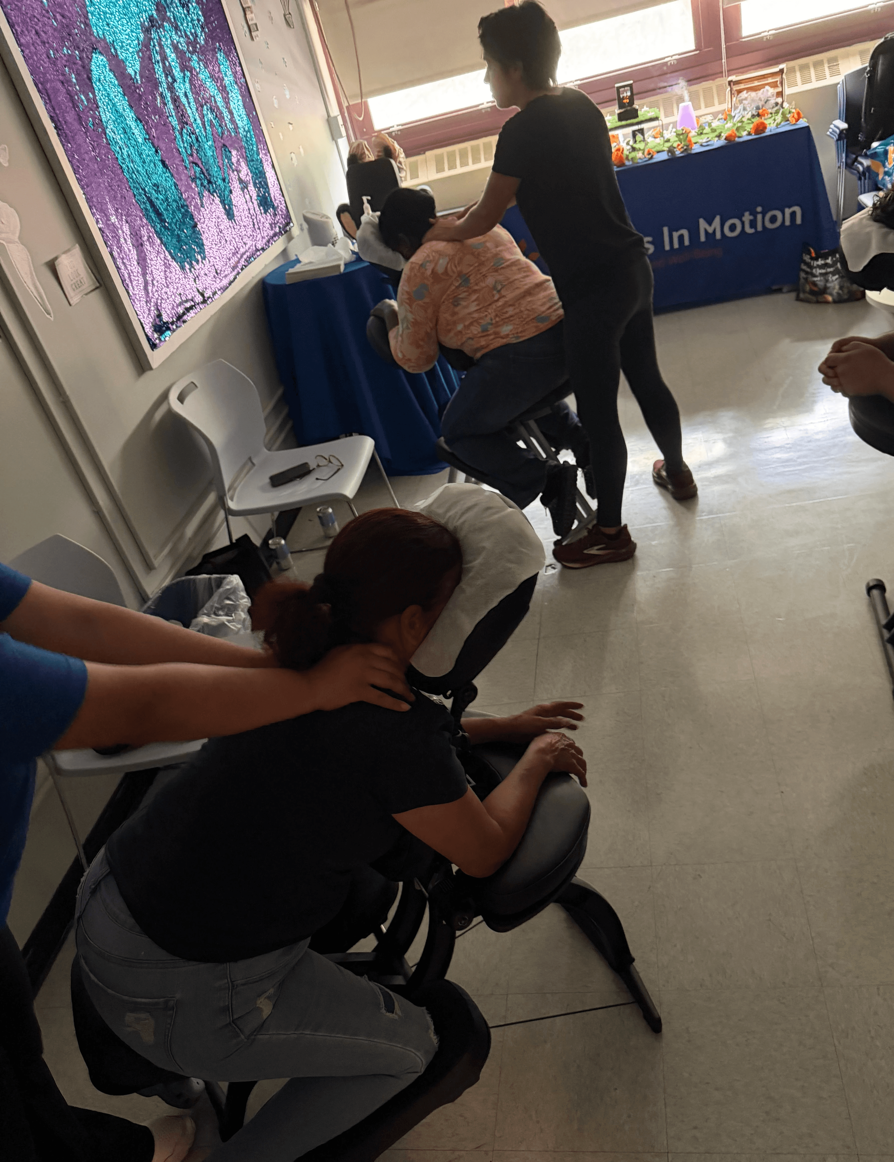 Parents receive massages in a classroom.