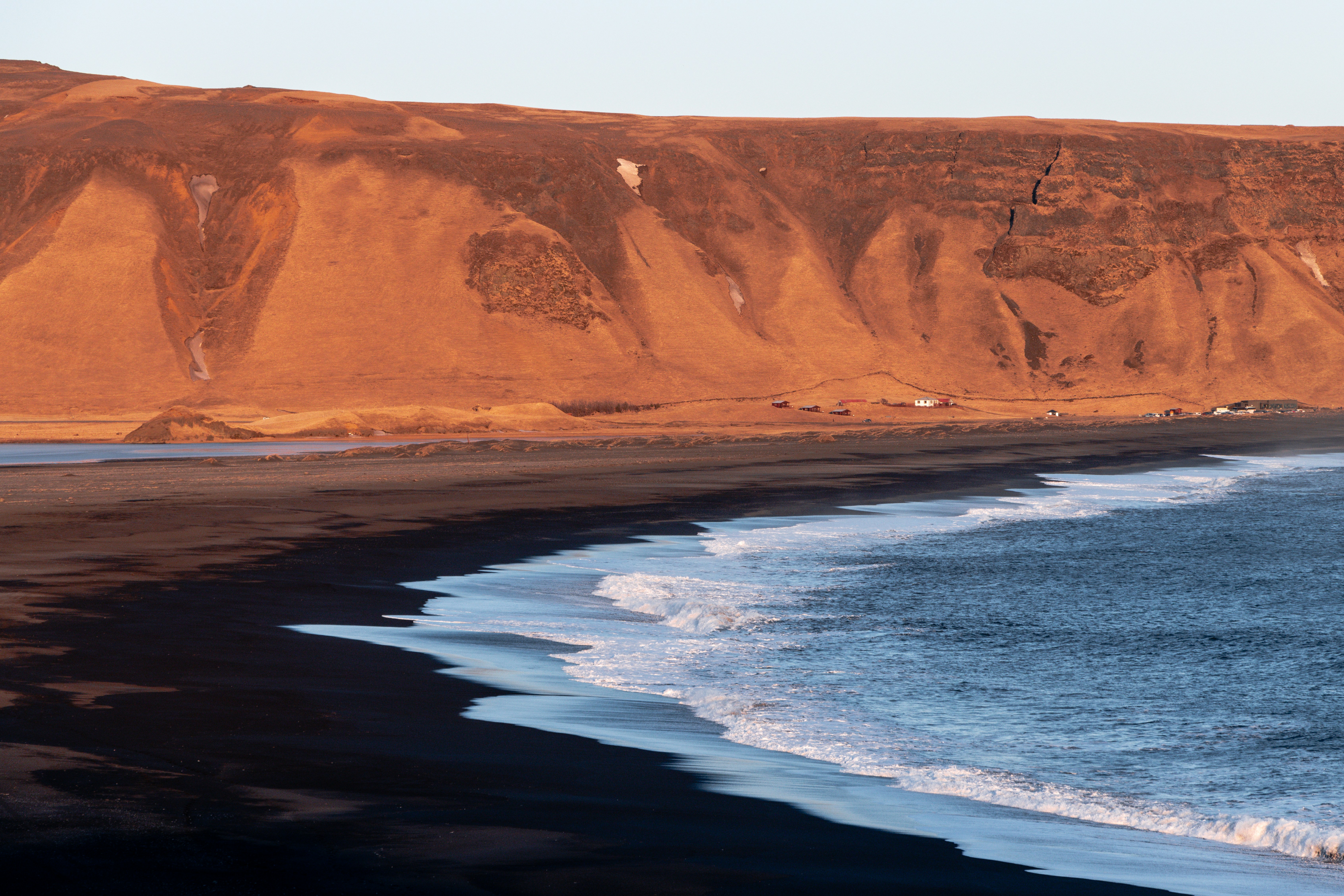 Black sand beach bathed in golden hour light in South Iceland.