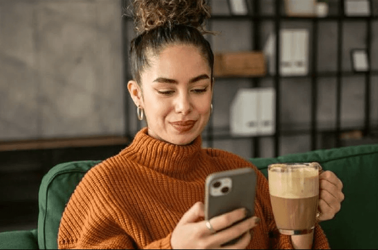 Two professionals, a man in a gray shirt and a woman in a white blouse, review documents at a desk.