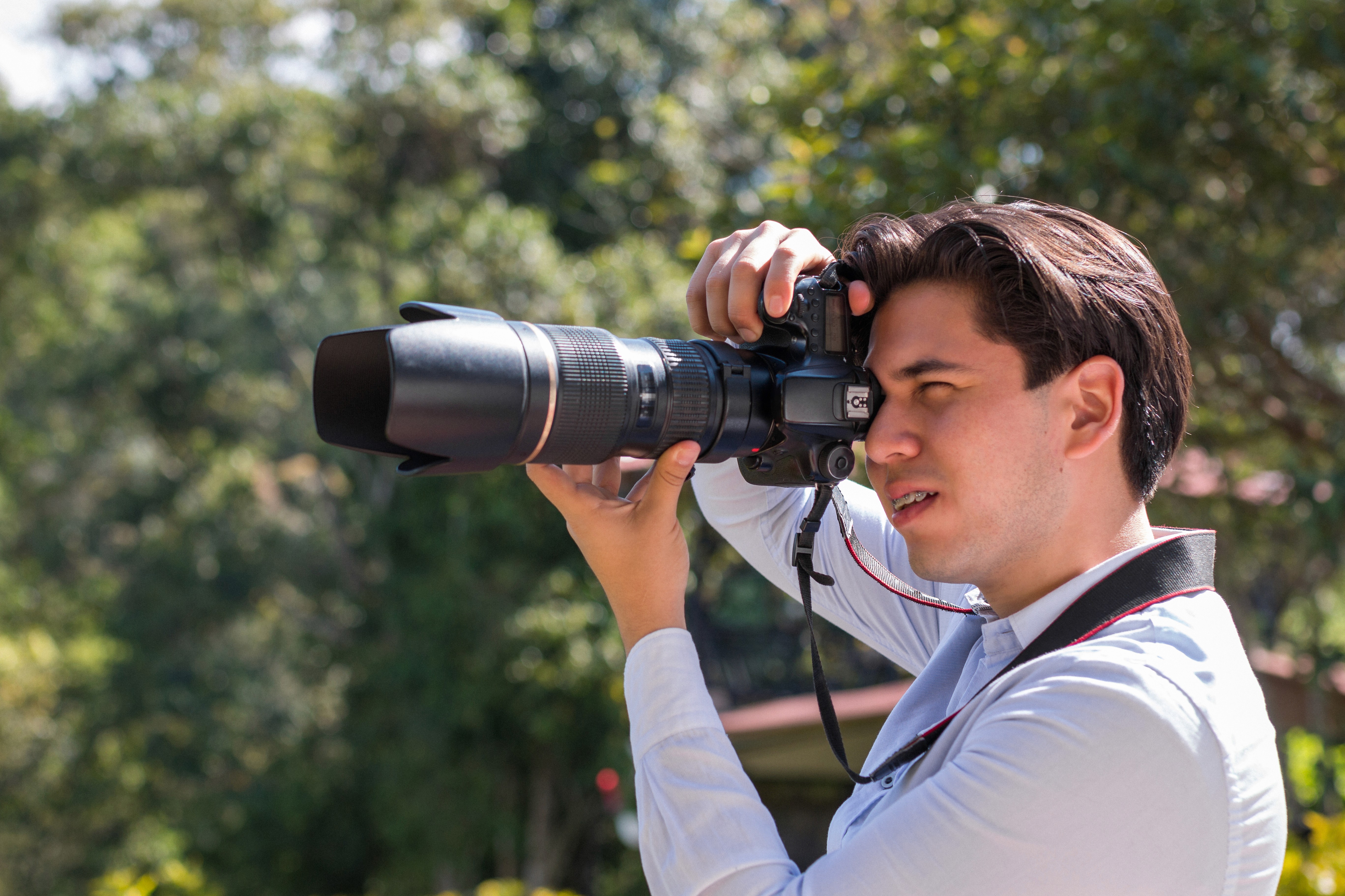 Male wedding photographer shooting with telephoto lens outdoors