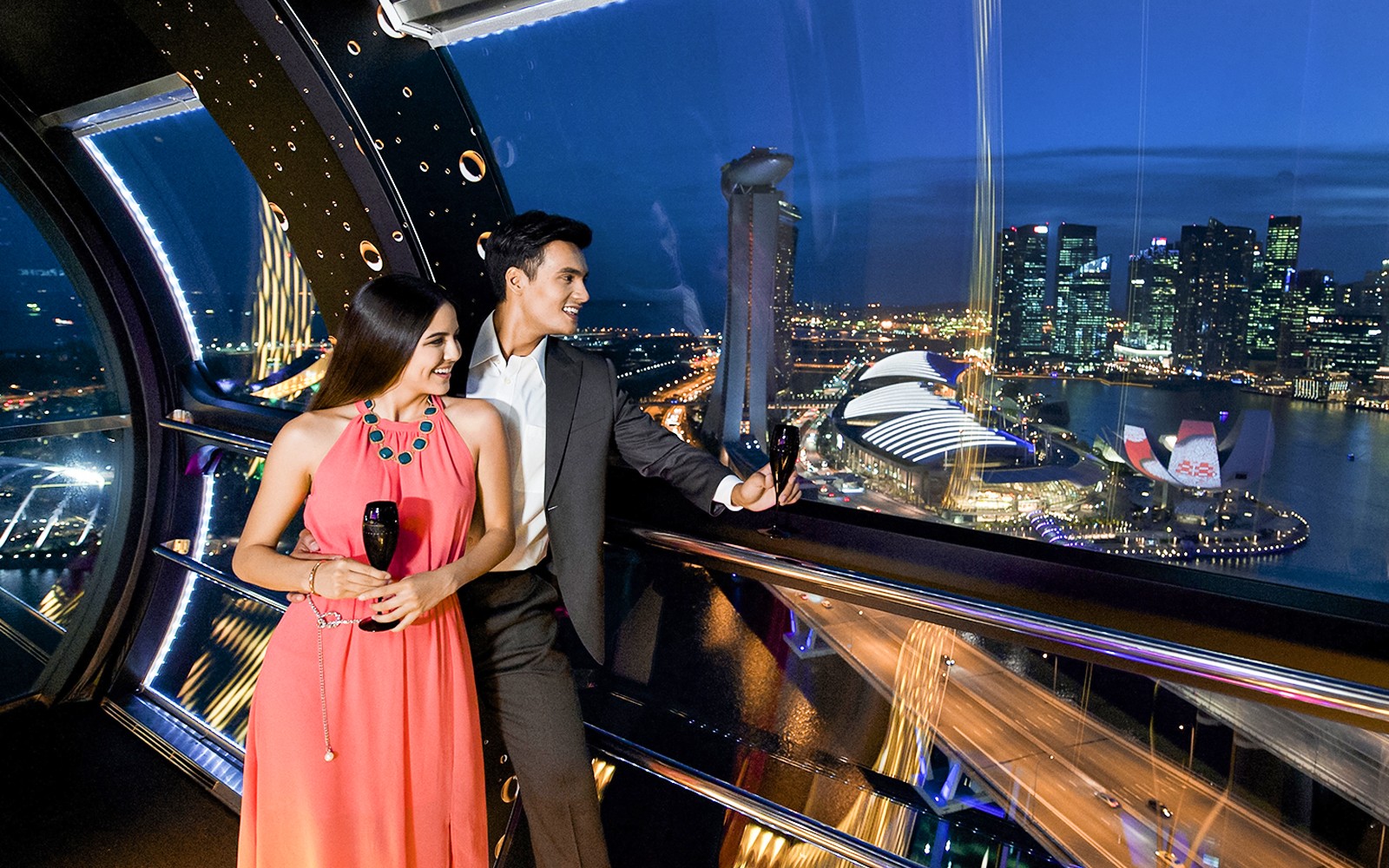 Couple toasting with champagne on Singapore Flyer during 165 Sky Dining experience.