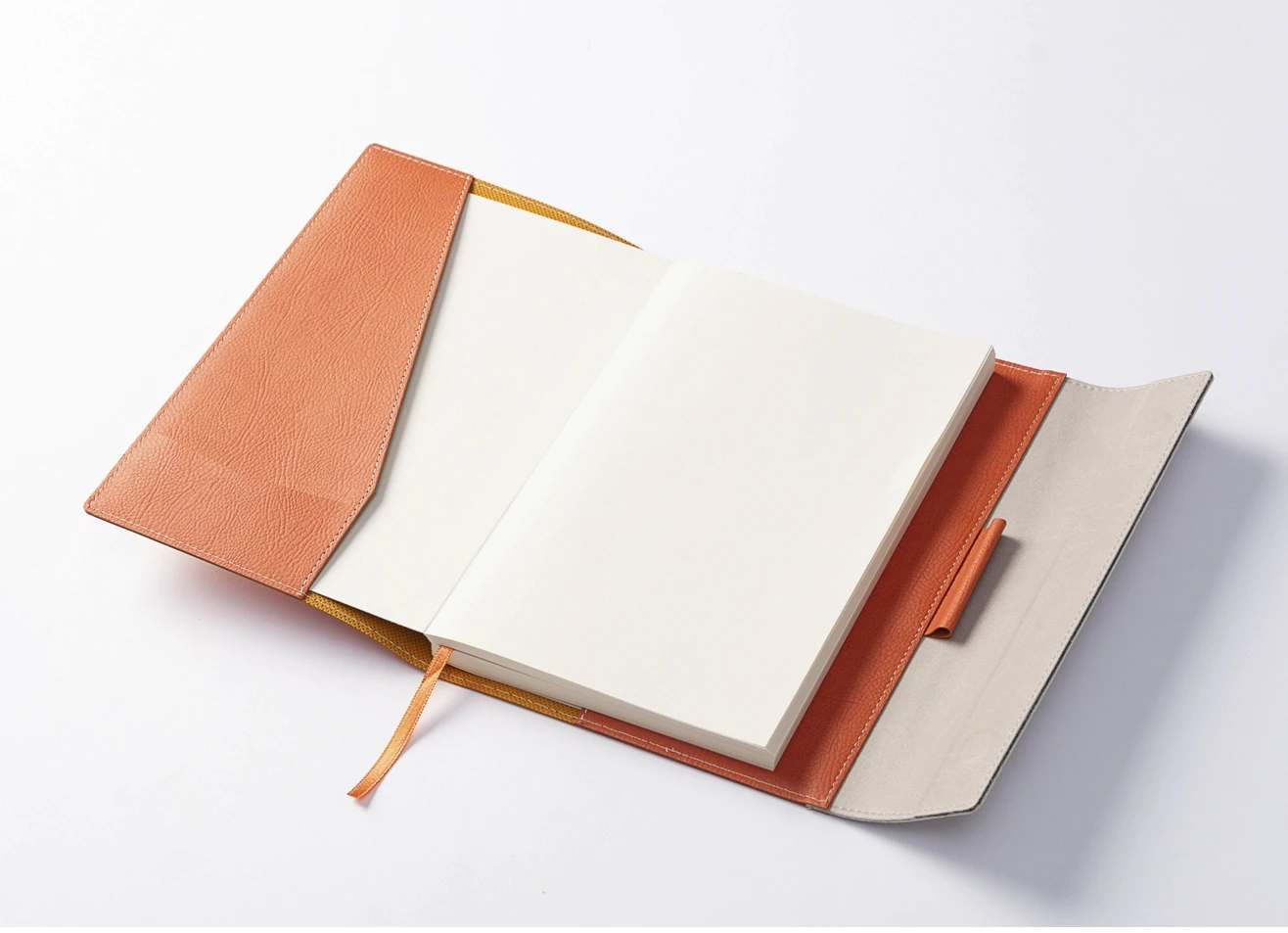 Open leather journal showing ivory pages, inner paper pocket, and pen loop