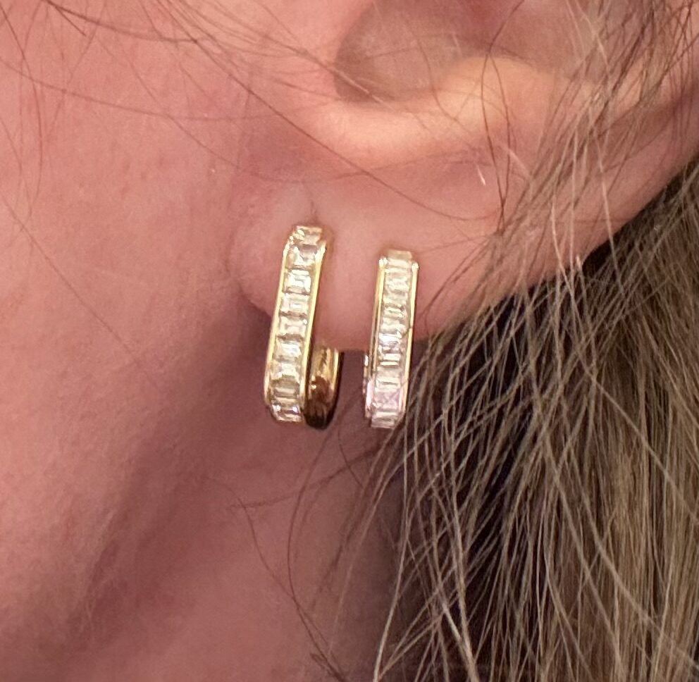 Diamond baguette huggie hoops worn on the ear