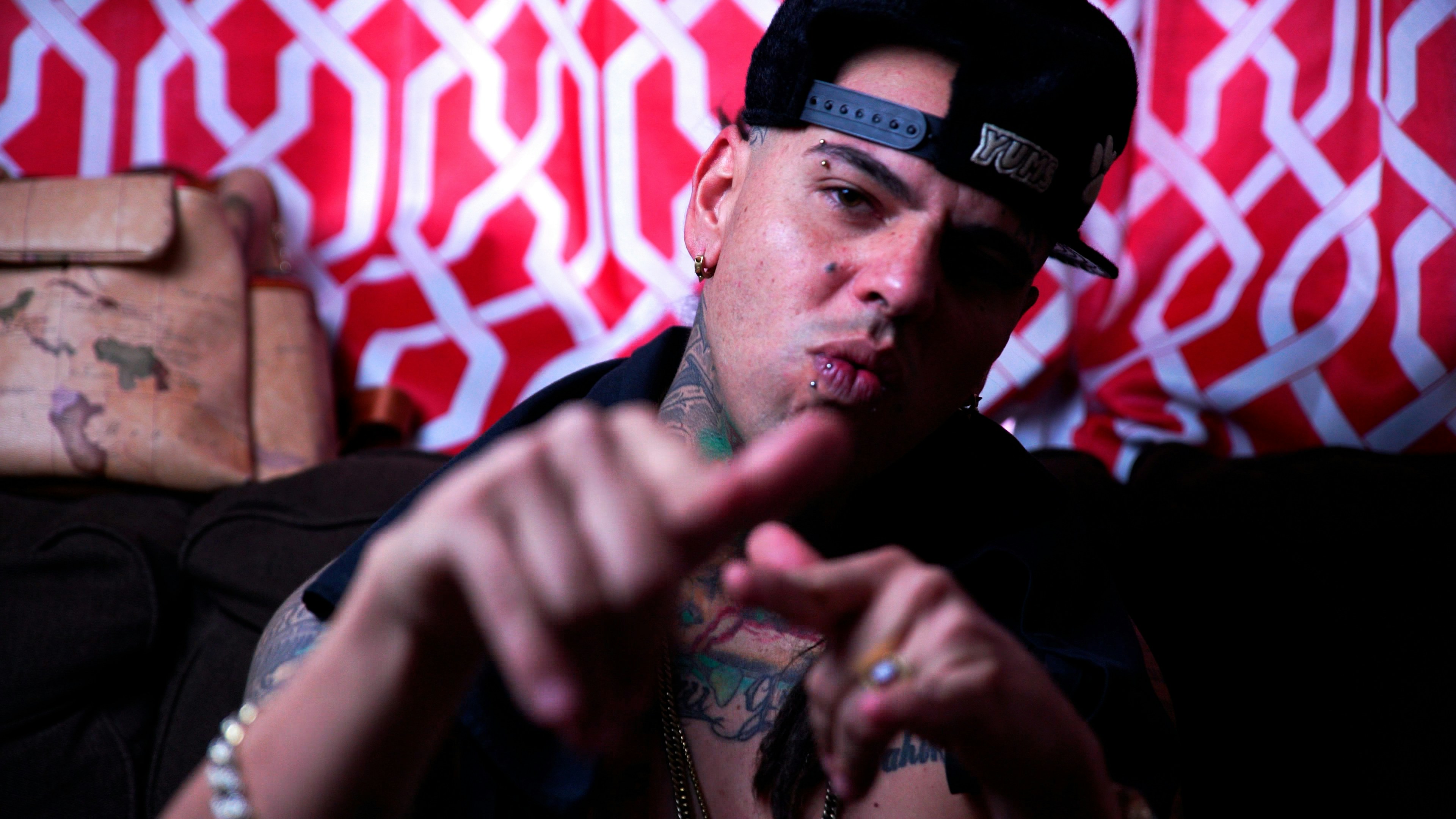a man with tattoos pointing at the camera