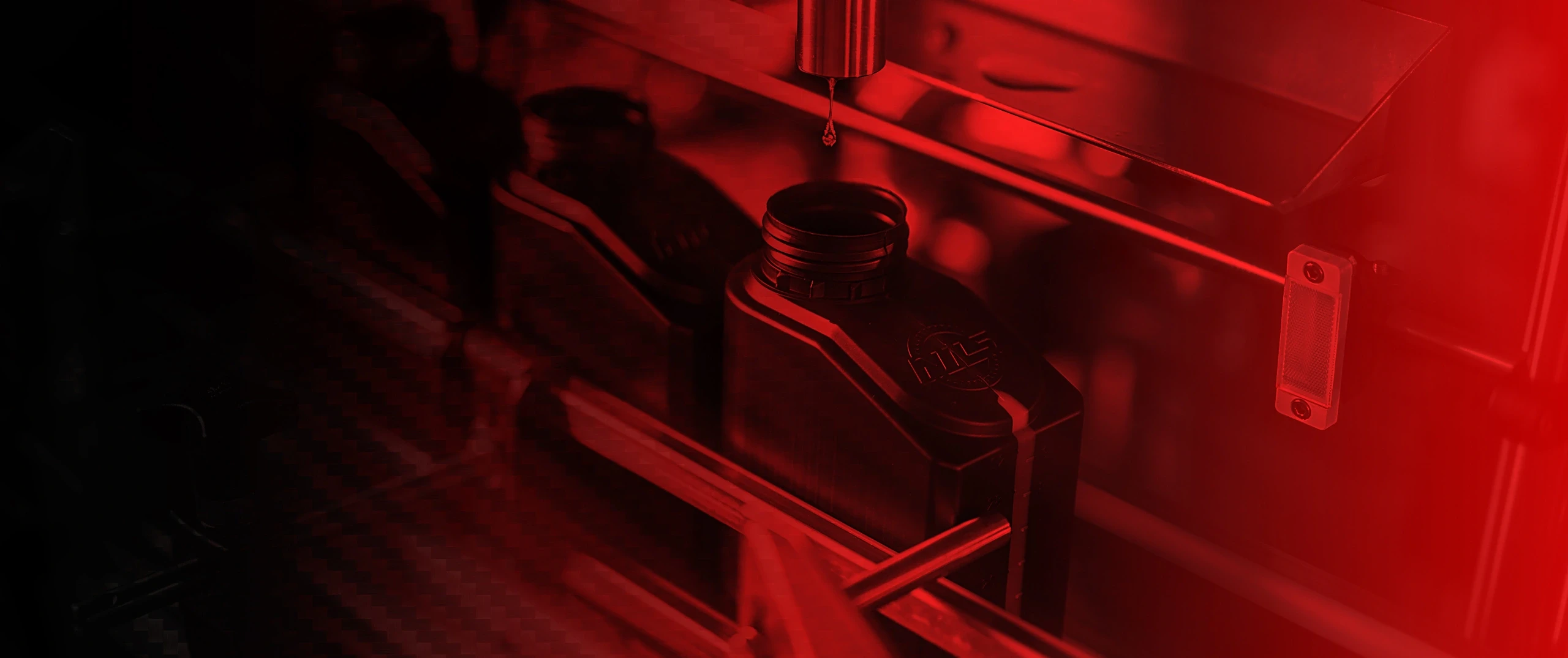 Box professionale da gara con illuminazione LED rossa, una moto sportiva, porta pneumatici e un tecnico al lavoro