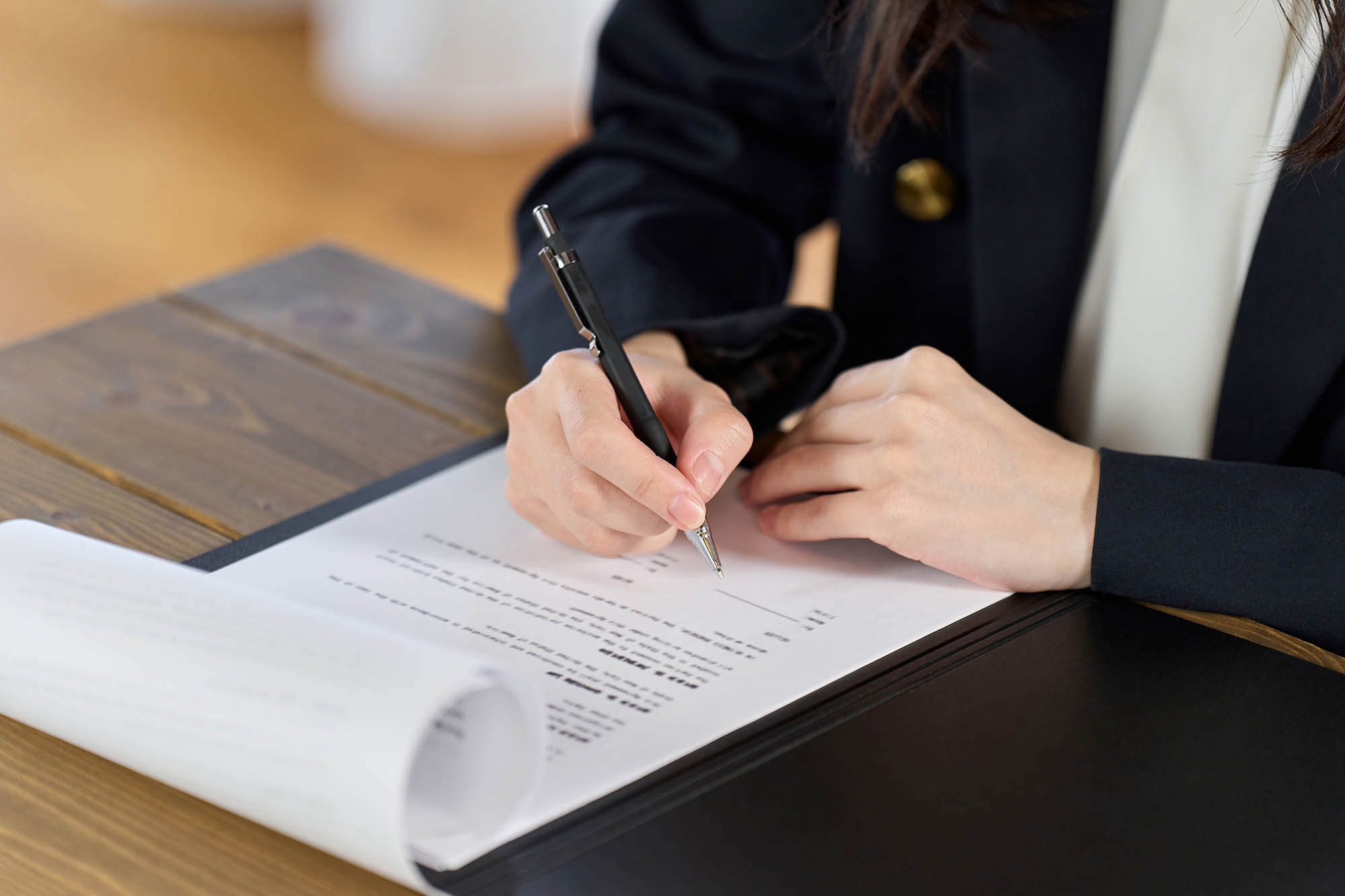 Businesswoman signing contract and discusses types of licenses in Dubai as part of Dubai economic department trade license renewal