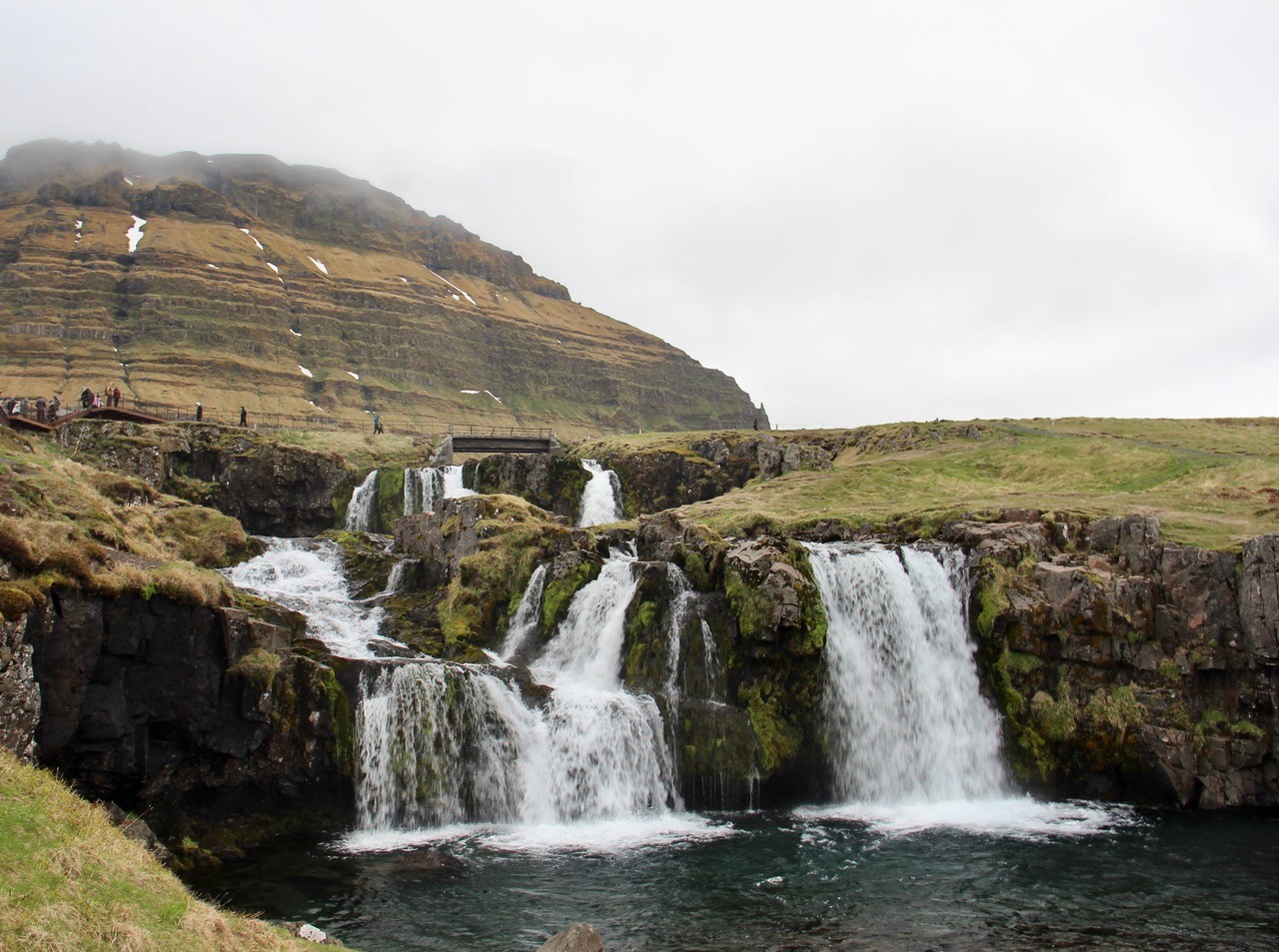 Kirkjufellsfoss Waterfall in Iceland, featuring many tiers and levels, and finishing in a large pool of water. 