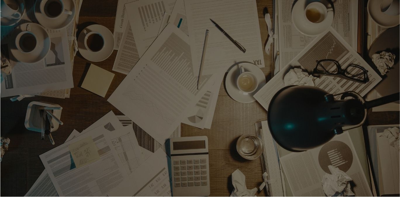 Busy small business owner's desk with notebooks, coffee, and a phone — representing the overwhelm of running a brand without support