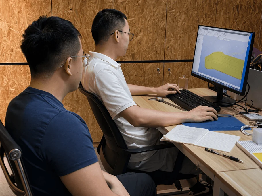Engineers reviewing a mechanical design on a computer