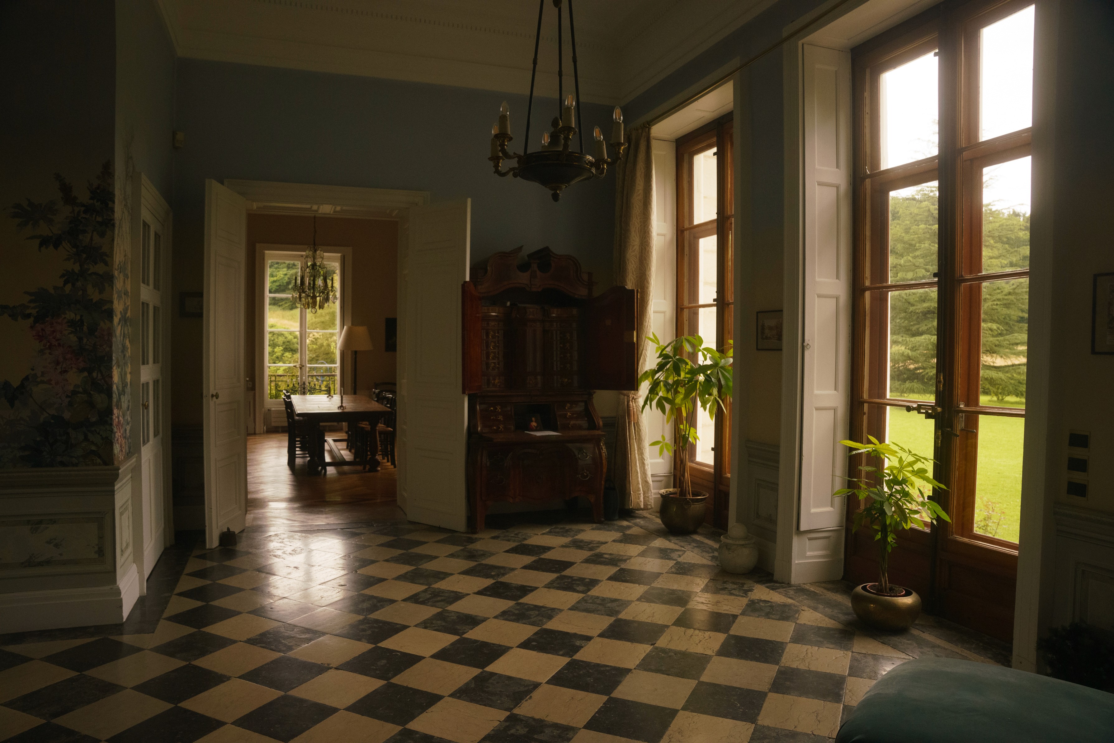 Hallway with a black and white chequerboard floor leading through the house