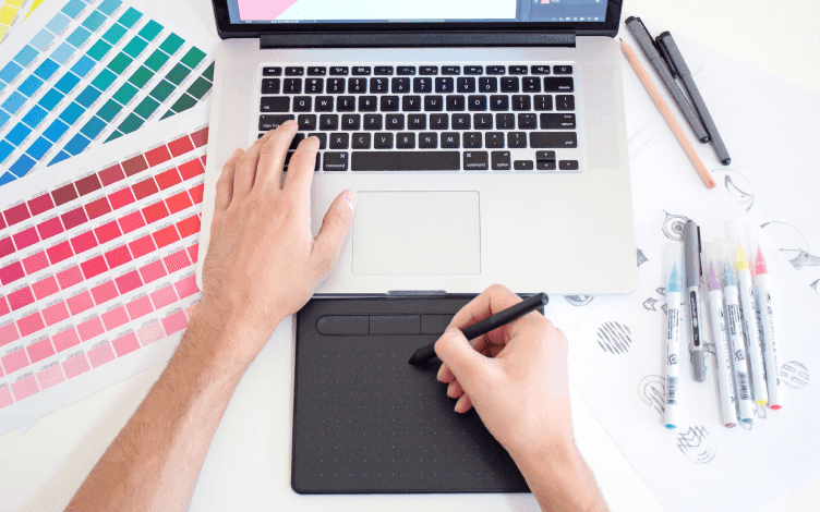 person with laptop and sketch pad