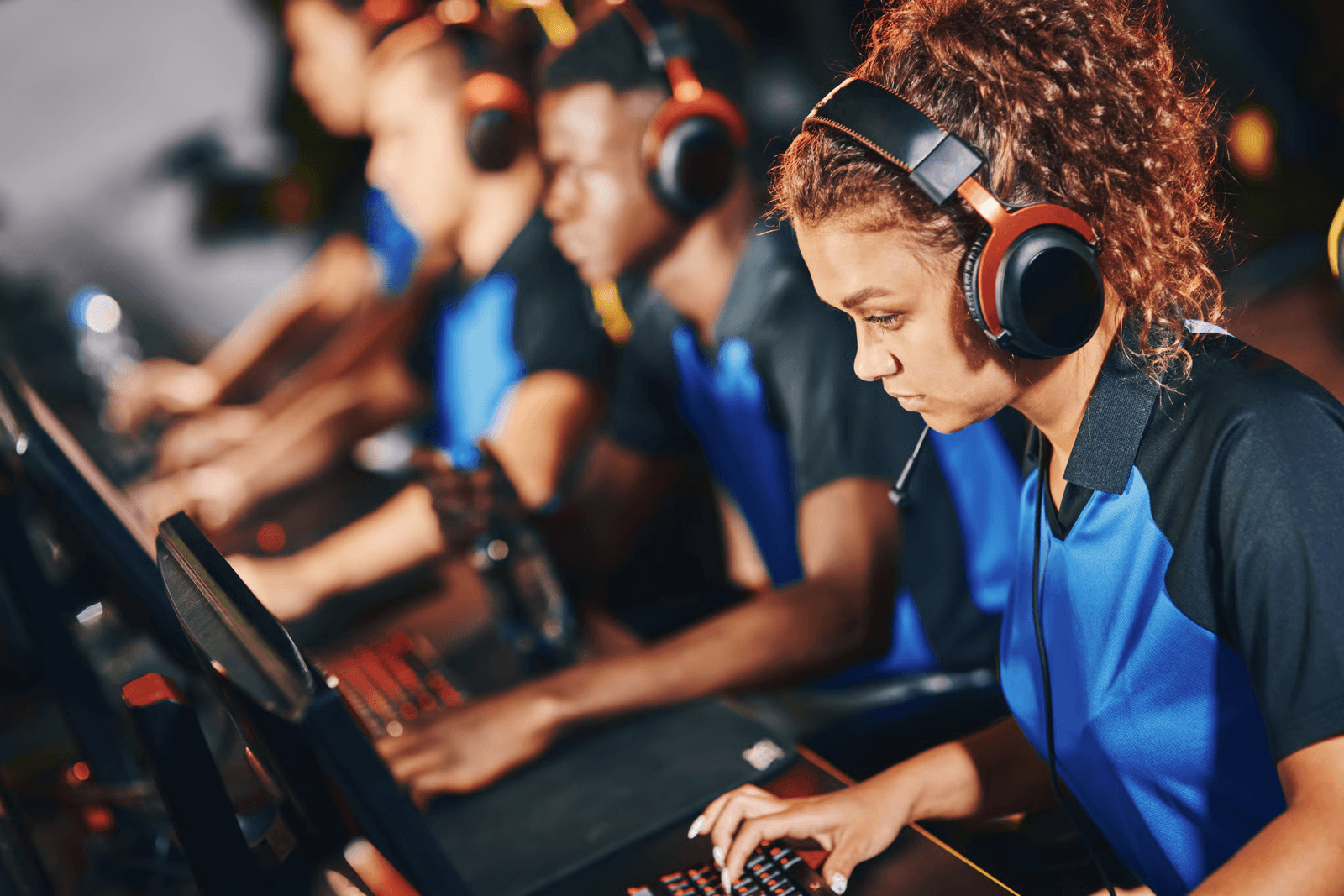 A team of esports players wearing headsets and concentrating during a competitive gaming match.