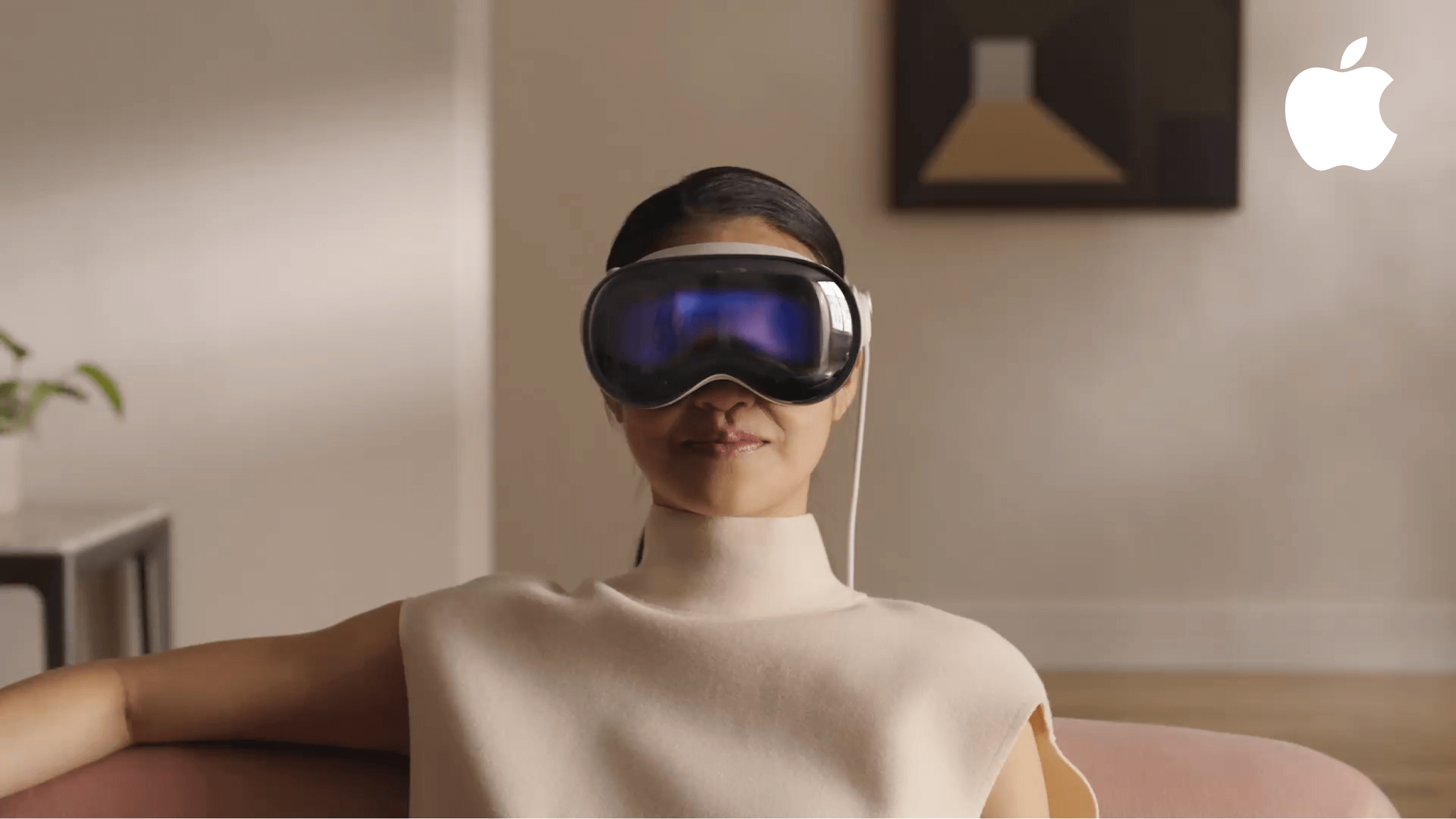 A user wearing the Apple Vision Pro headset in a home environment, showcasing the device's sleek glass front and spatial computing capabilities for mixed reality immersion.