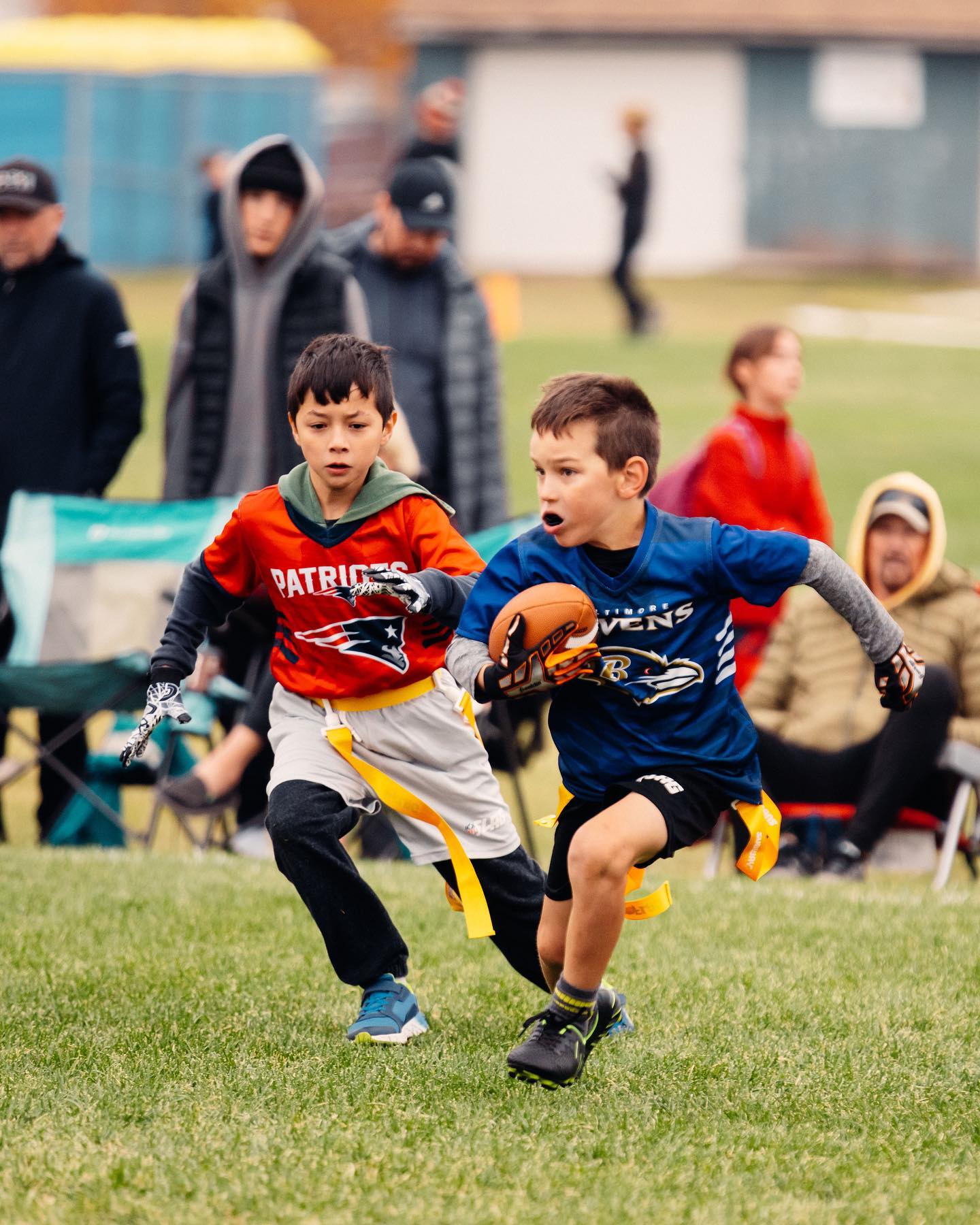 Young players running with the ball during an NFL Flag football game managed with TeamLinkt