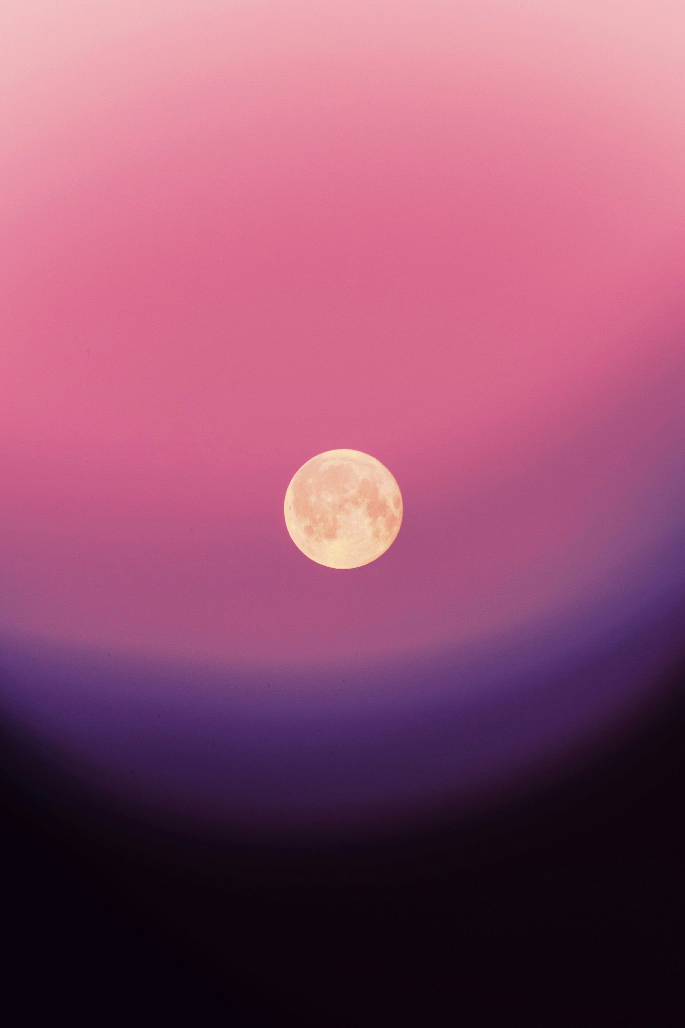 Full moon in a gradient pink and purple sky.