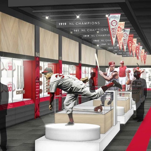 A baseball museum exhibit with player mannequins, display cases, and championship banners hanging from the ceiling.