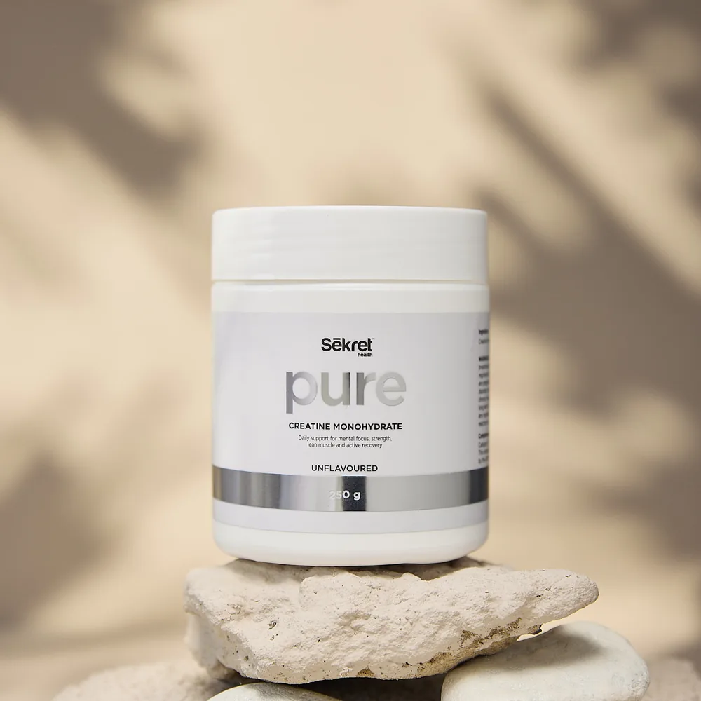 A tub of Sekret Pure creatine resting on stone