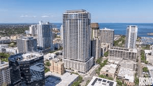 Aerial view of Art House St. Petersburg showing modern multi-story residential building with waterfront location and downtown skyline