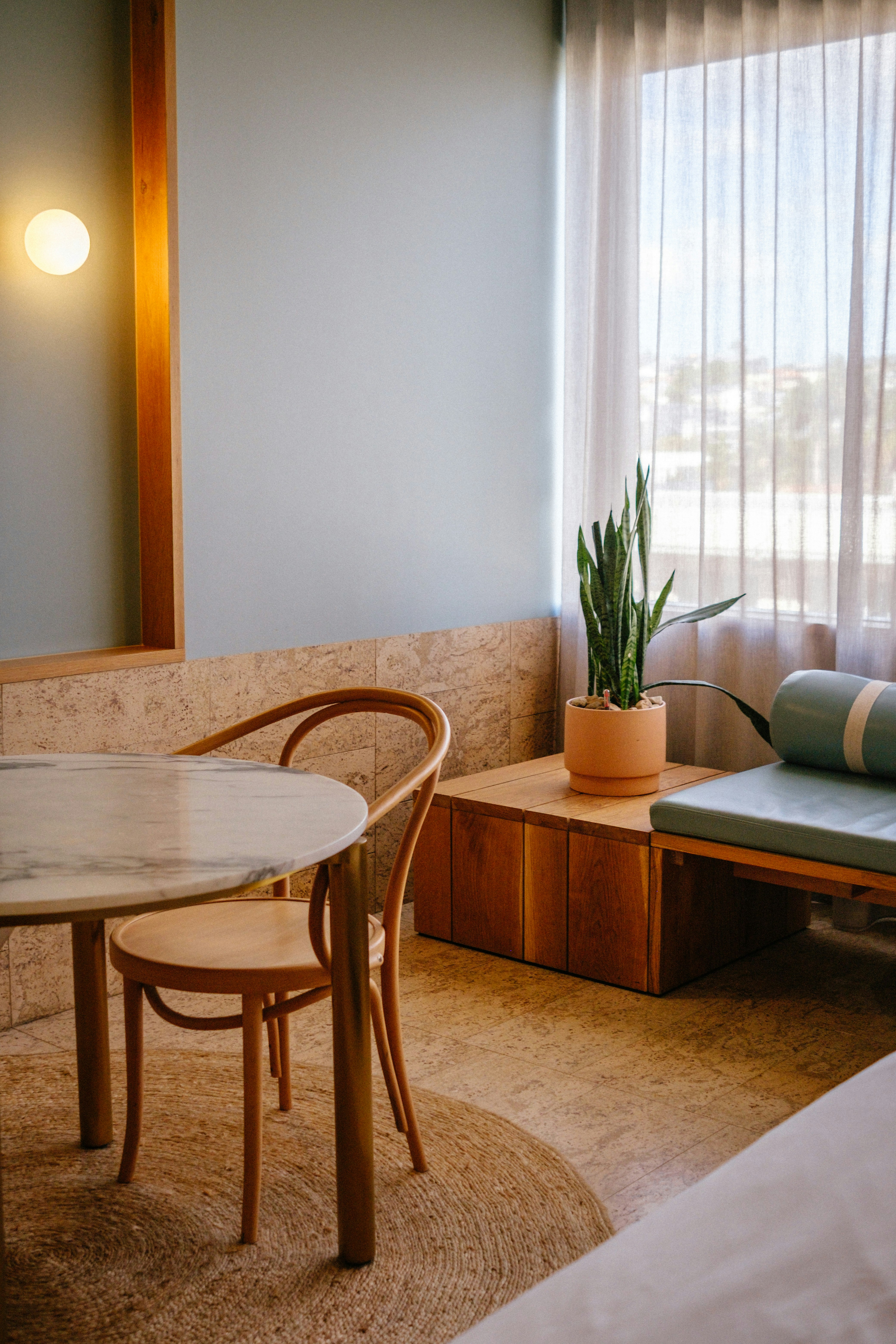 Modern room with marble table and potted snake plant.