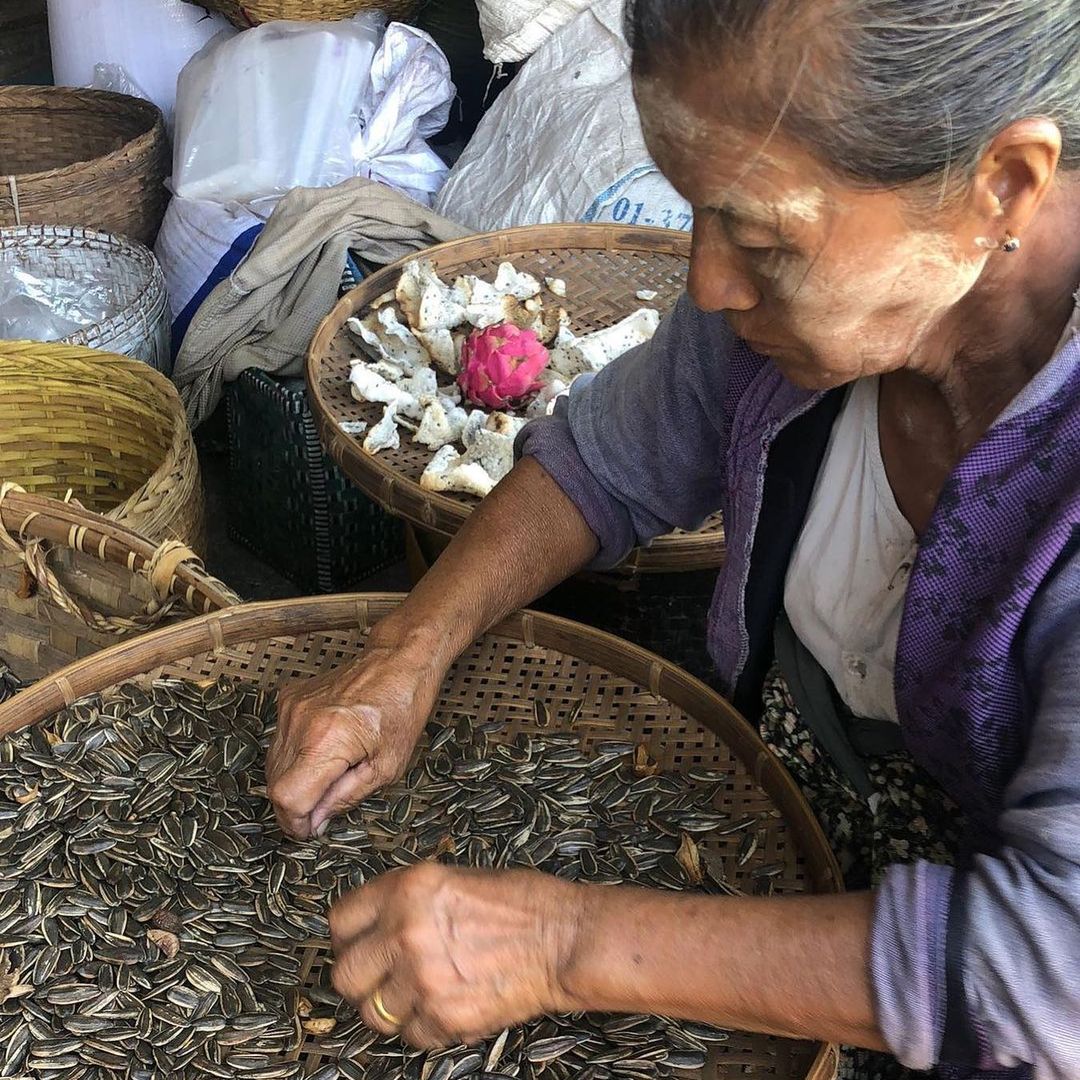 Woman working with seeds in bamboo tray