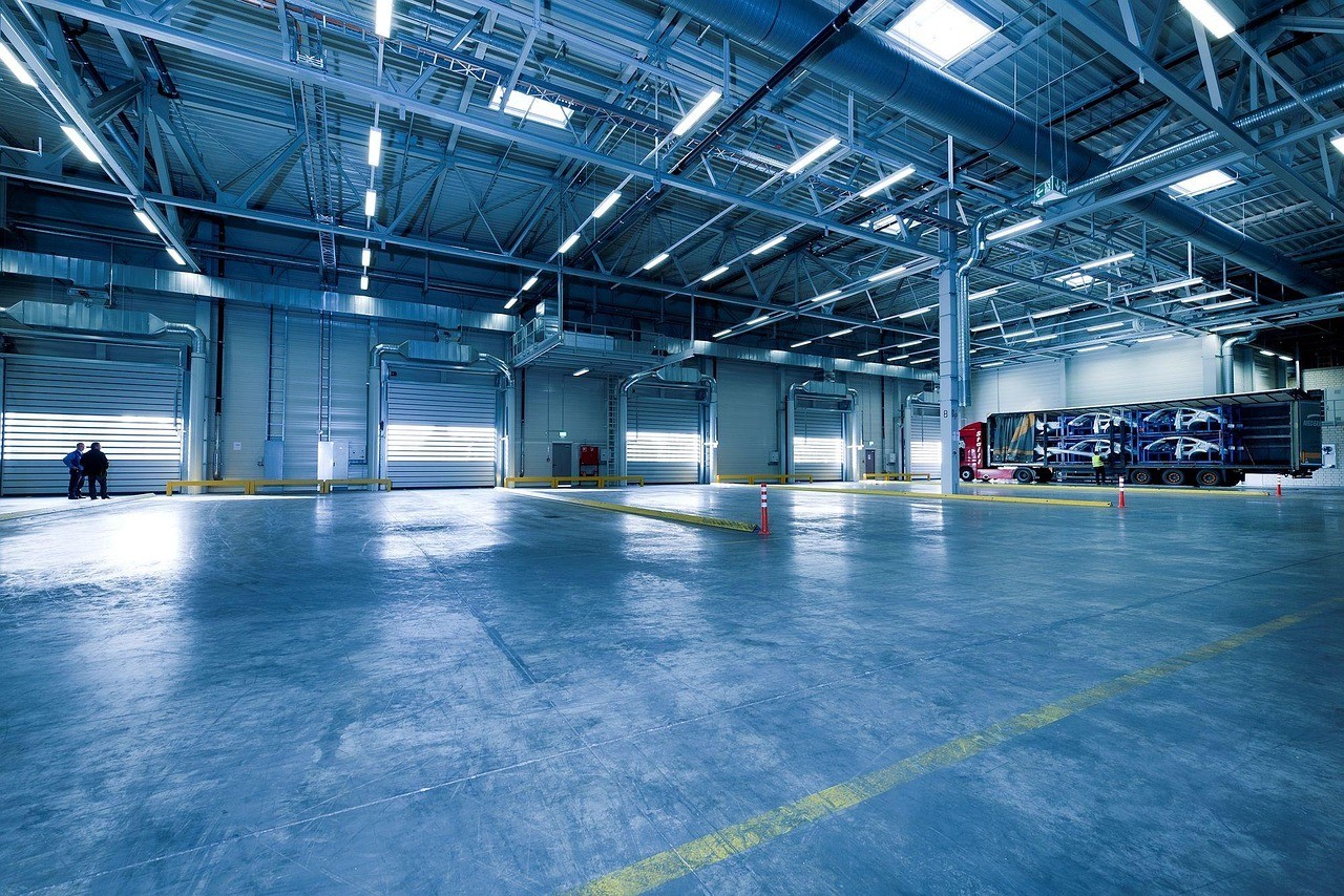 Enterprise Self Storage warehouse interior with loading bay doors, truck with cars, and security features in California.