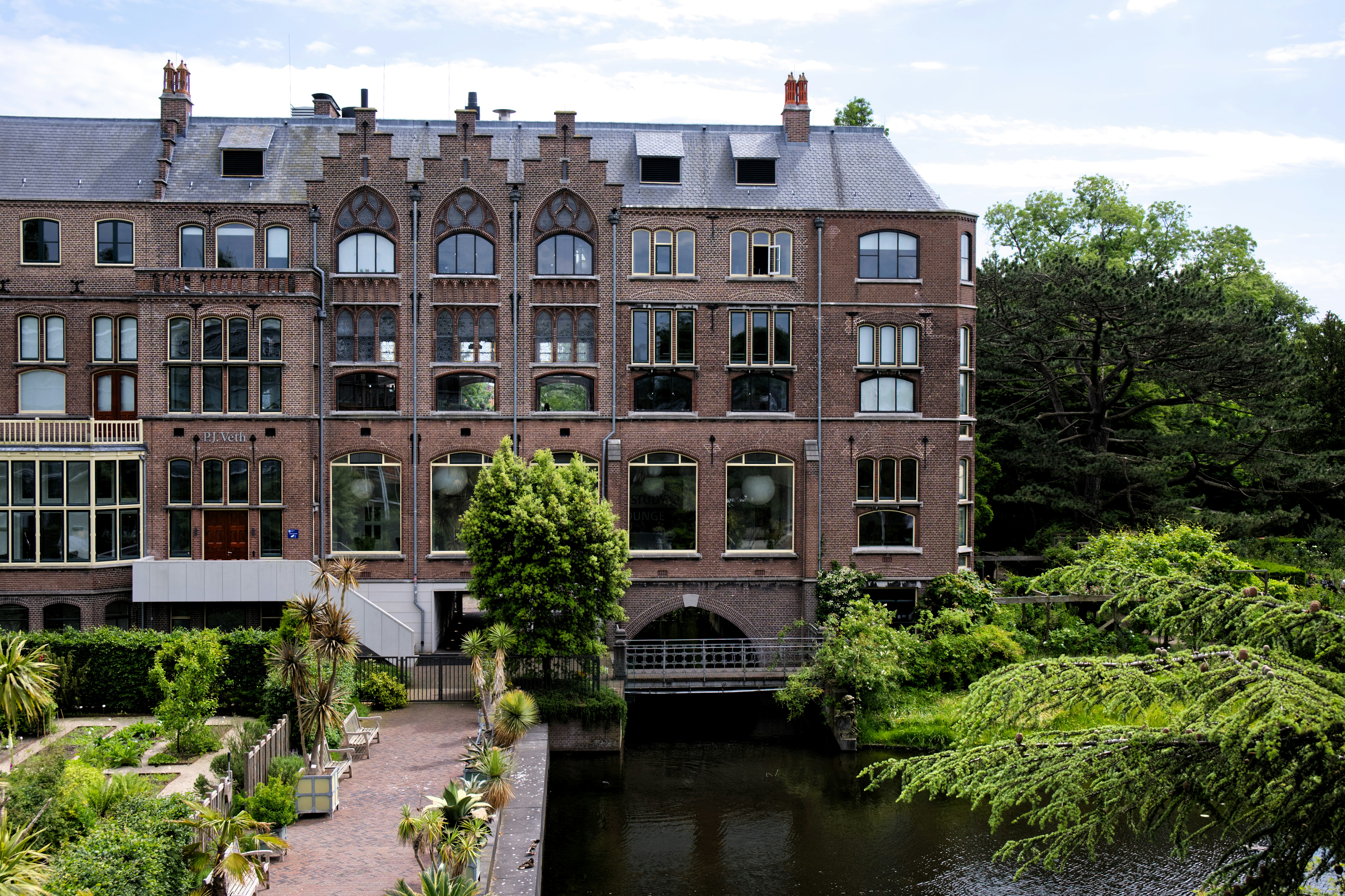 a large brick building with many windows next to a river